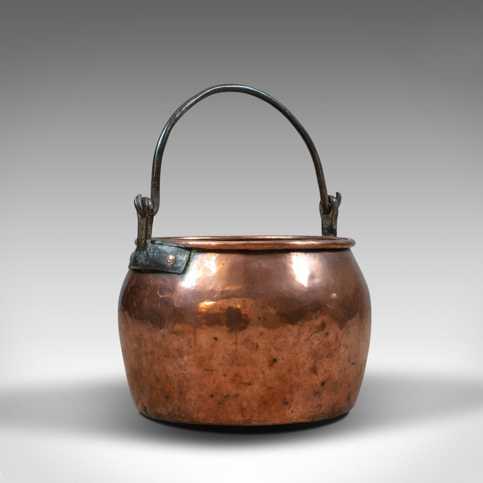 This is an antique copper cauldron. A heavy, English, Georgian pot with iron handle, ideal as a fireside log or coal scuttle, dating to the 18th century.

A mid-sized copper cauldron in fine order throughout
Of good proportion and attractive