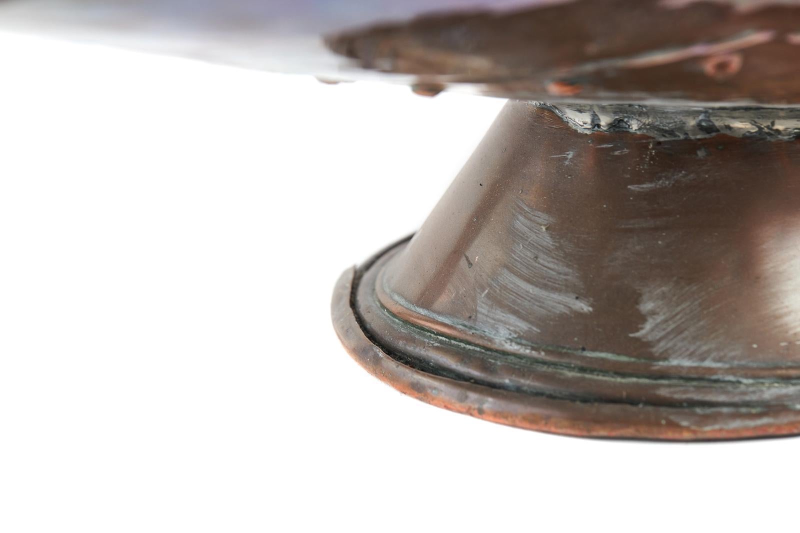 In vendita questo antico carbonaio in rame del XIX secolo, dalla classica forma a casco, con maniglia a bilico nella parte superiore e maniglia decorativa per il trasporto nella parte posteriore, sollevato su una base circolare.
