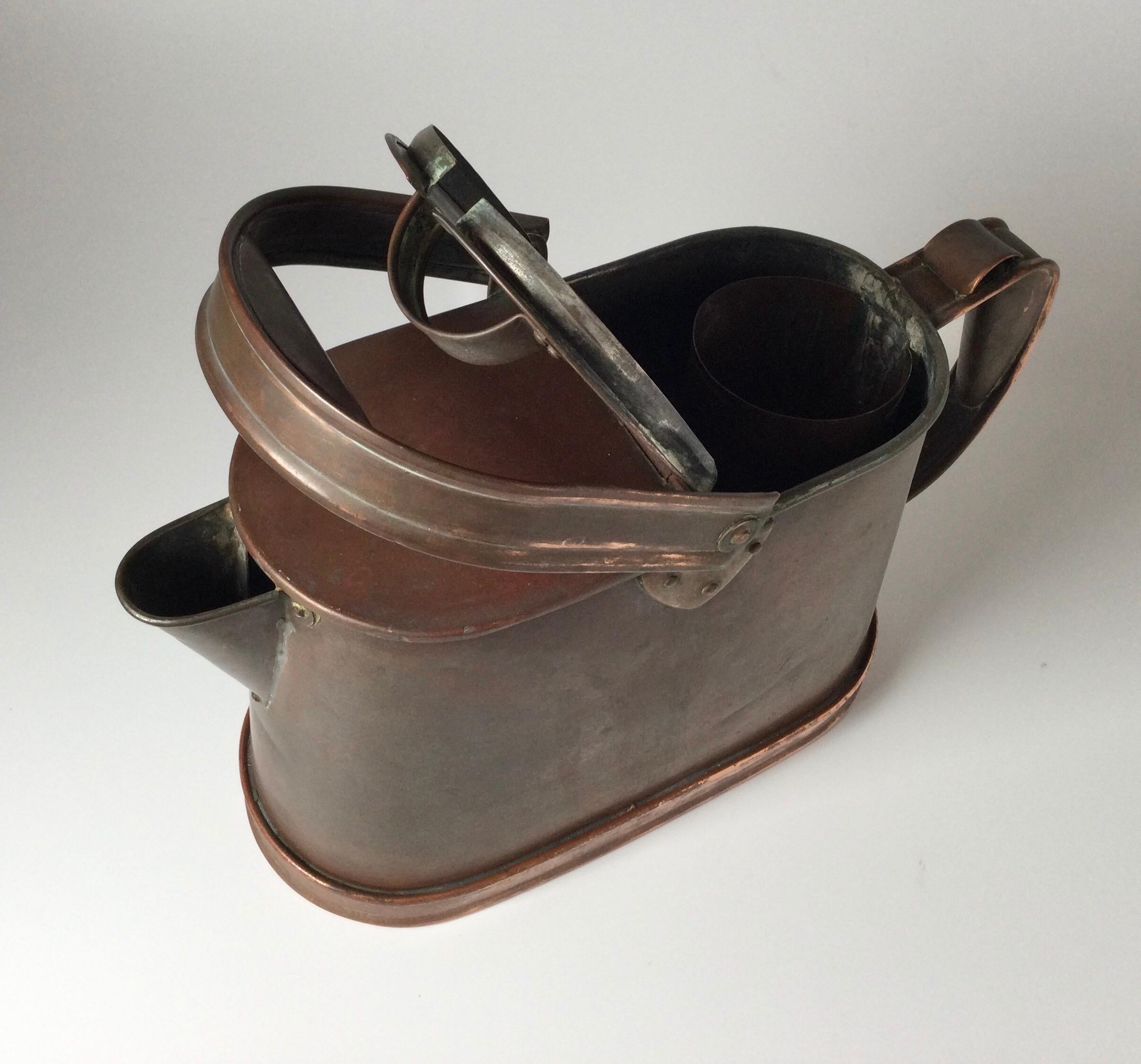 This classic style English watering can has a flower holder under the lid, making it a perfect tool for watering and cutting garden flowers. The copper has aged to a beautiful patina. This is an especially nice piece! Measures: 8” tall by 10” long