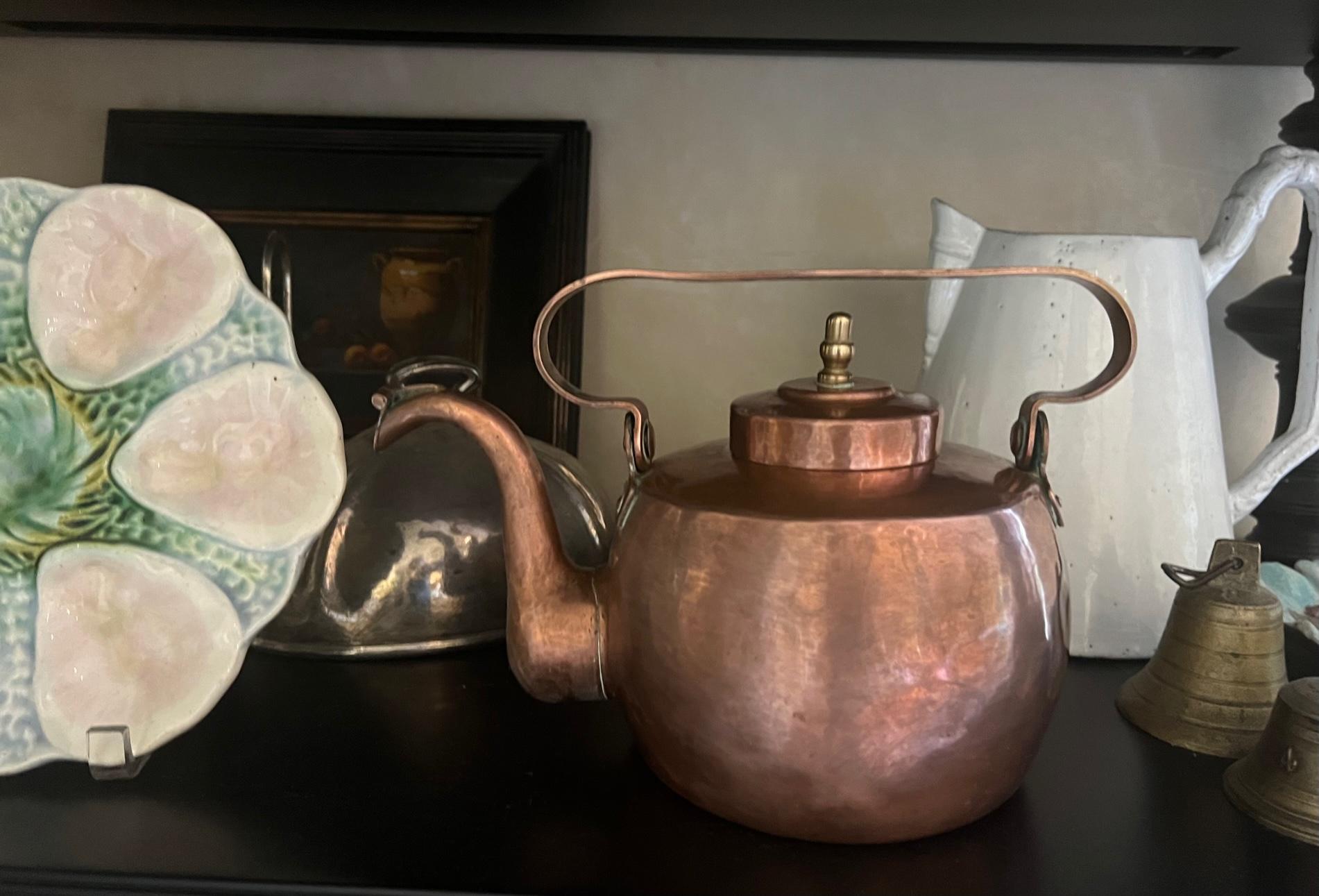 Antique copper kettle made in the 1800s. The lid has a brass handle and the seams on the bottom of the kettle are dovetailed. The kettle itself has an unusual shaped flat top handle.