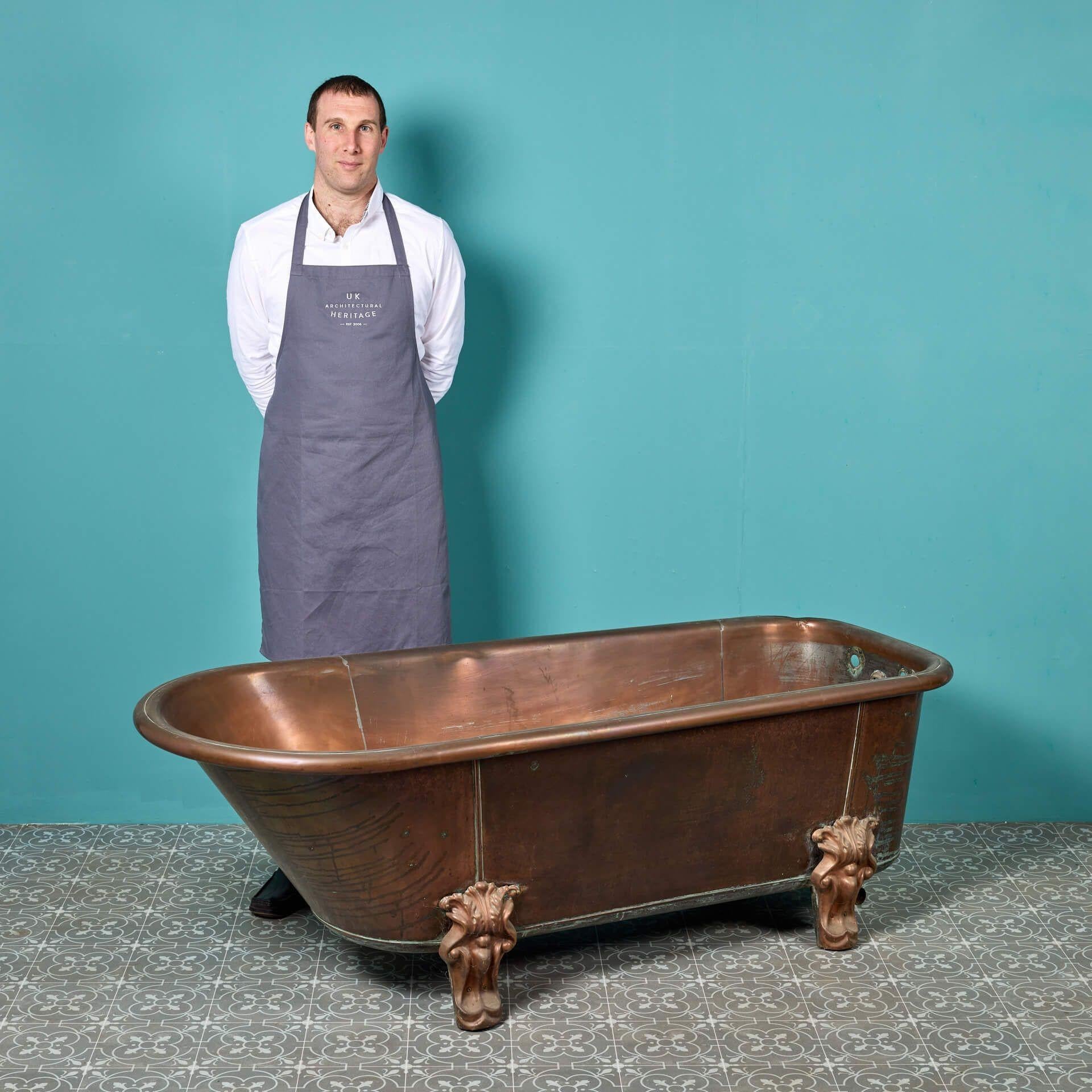 An antique English copper roll top bathtub by Ewart and Son Ltd, circa 1890. A beautiful piece for the vintage bathroom of an Edwardian or Victorian style property, this copper bath features a stylish roll top, decorative leg covers and an
