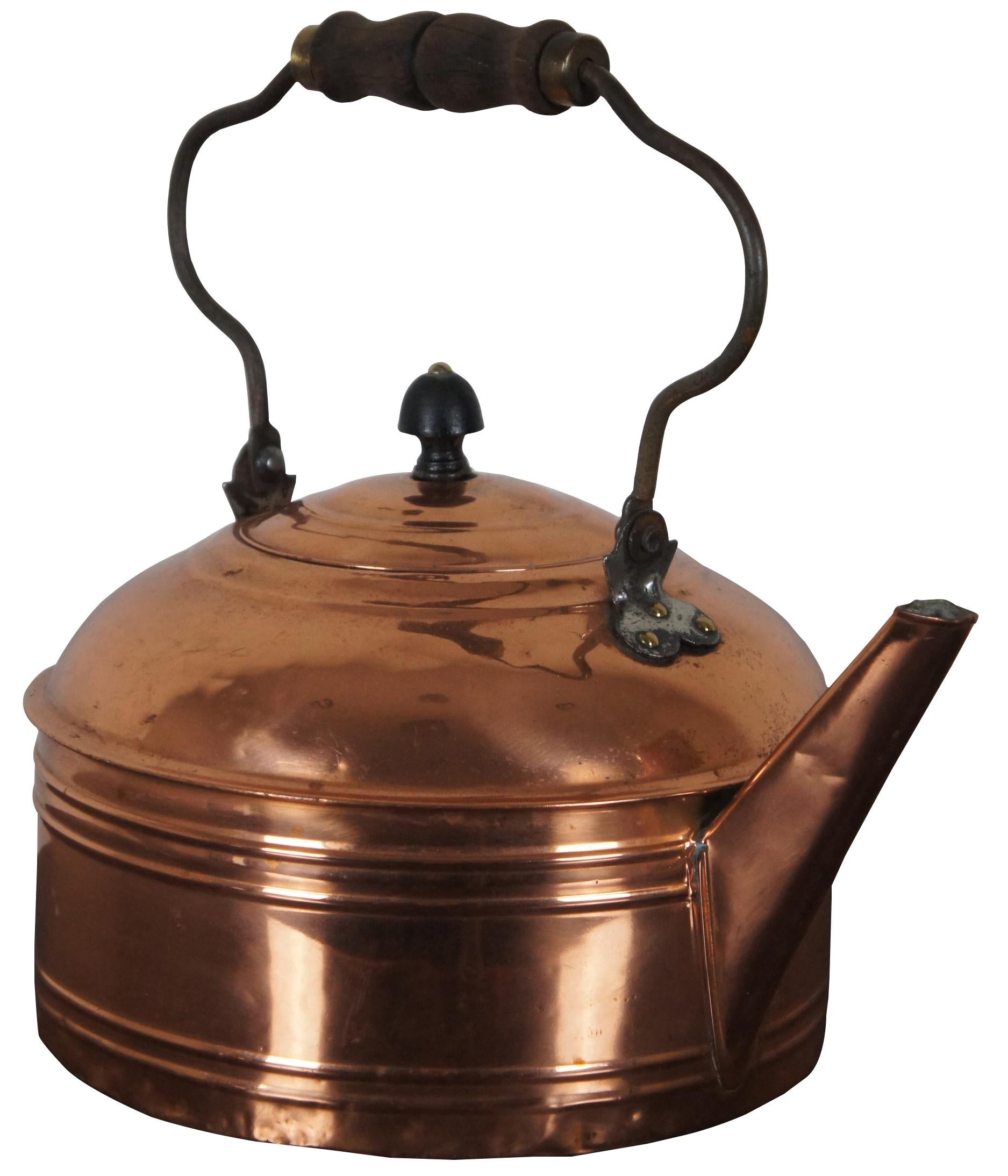 Very shiny antique copper tea kettle with straight spout and wood handle. Measures: 13
