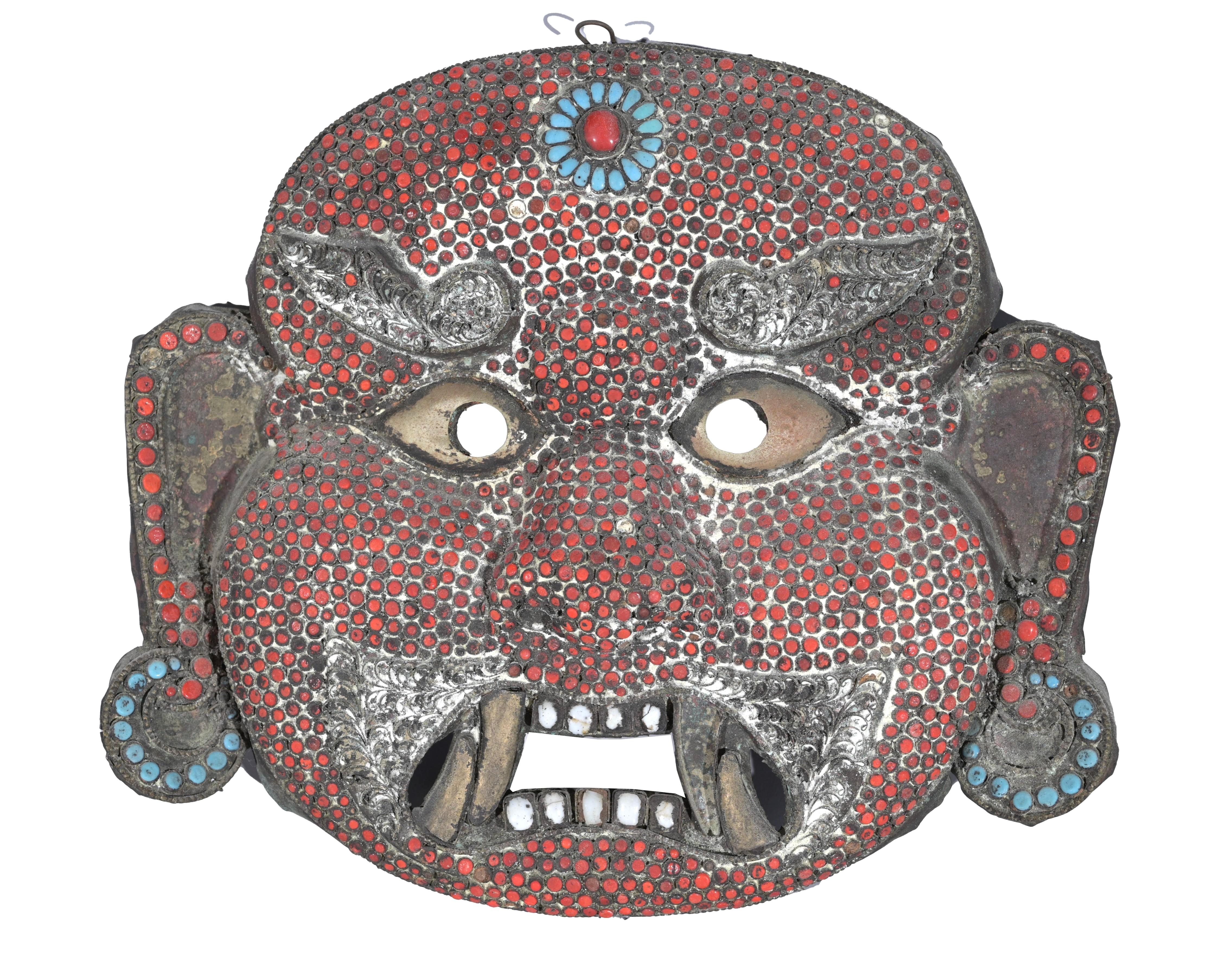 Unique 19th century copper Mahakala mask of Tibetan origin. This mask features a fierce looking creature with opened eyes and mouth with fangs and teeth showing. The masks served to ward off evil spirits and are among the most important symbols of