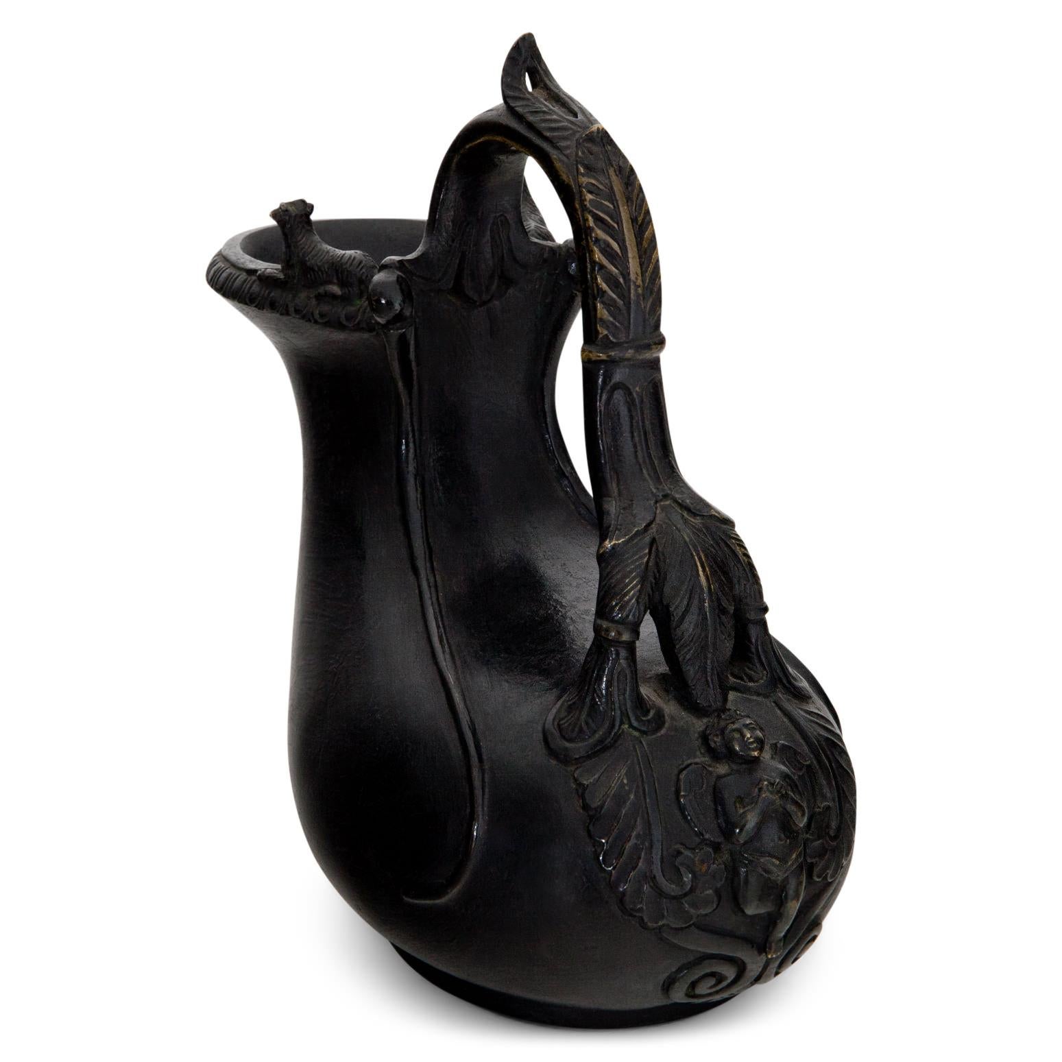 Piccolo vaso in bronzo del XIX secolo a forma di antico Askos con montoni appoggiati sull'ampia apertura e manico a forma di orecchio, decorato con foglie. La forma del corpo è una diretta interpretazione delle pelli del vino. Per oggetti simili