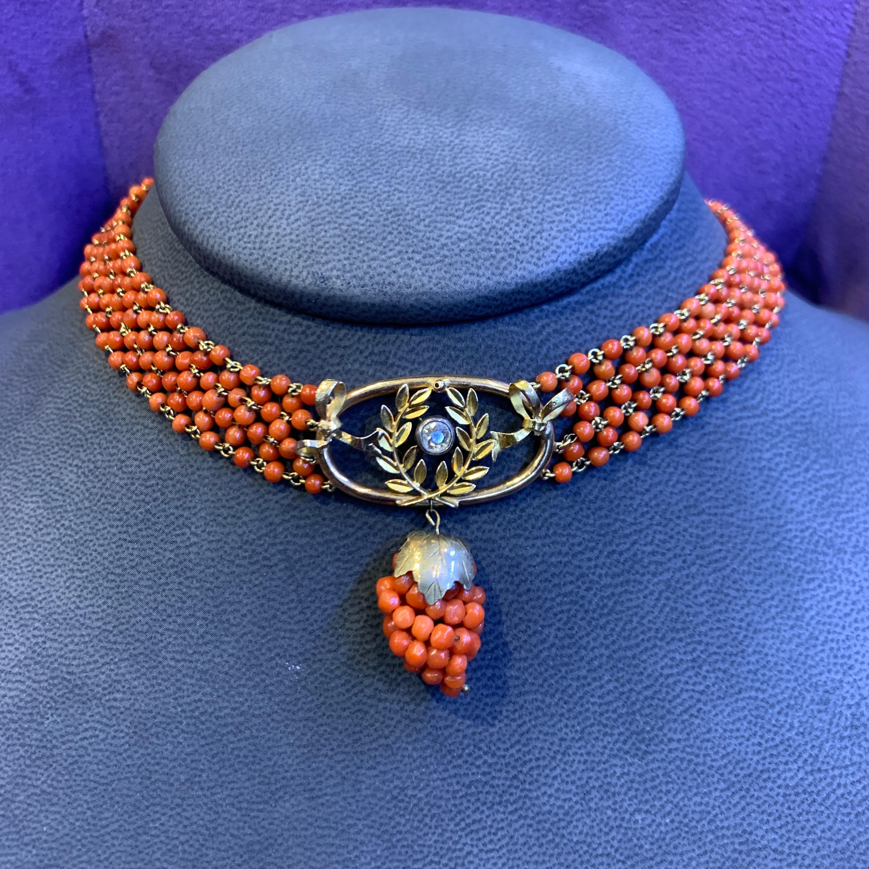 Antique Coral Choker Necklace.

A coral choker composed of coral beads that are elegantly connected by gold links. This piece also features a gold oval and wreath design, adorned with a dazzling round center diamond The pendant is further enhanced