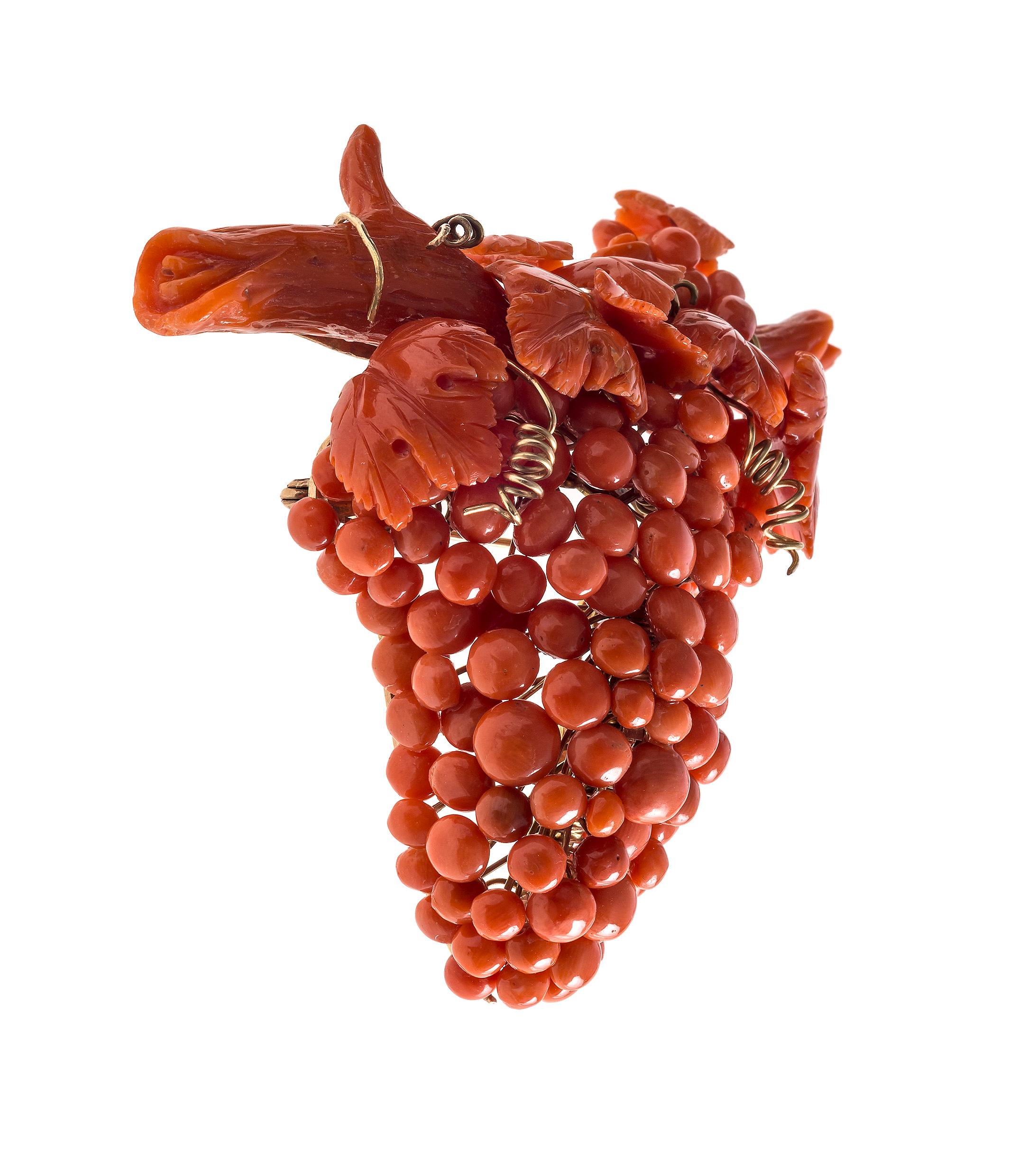 Cette magnifique broche en forme de raisin a été fabriquée en corallium rubrum, un corail méditerranéen, dans un atelier italien entre 1850 et 1860. Le raisin est constitué de boutons de différentes tailles, de feuilles de vigne et de fils dorés 14