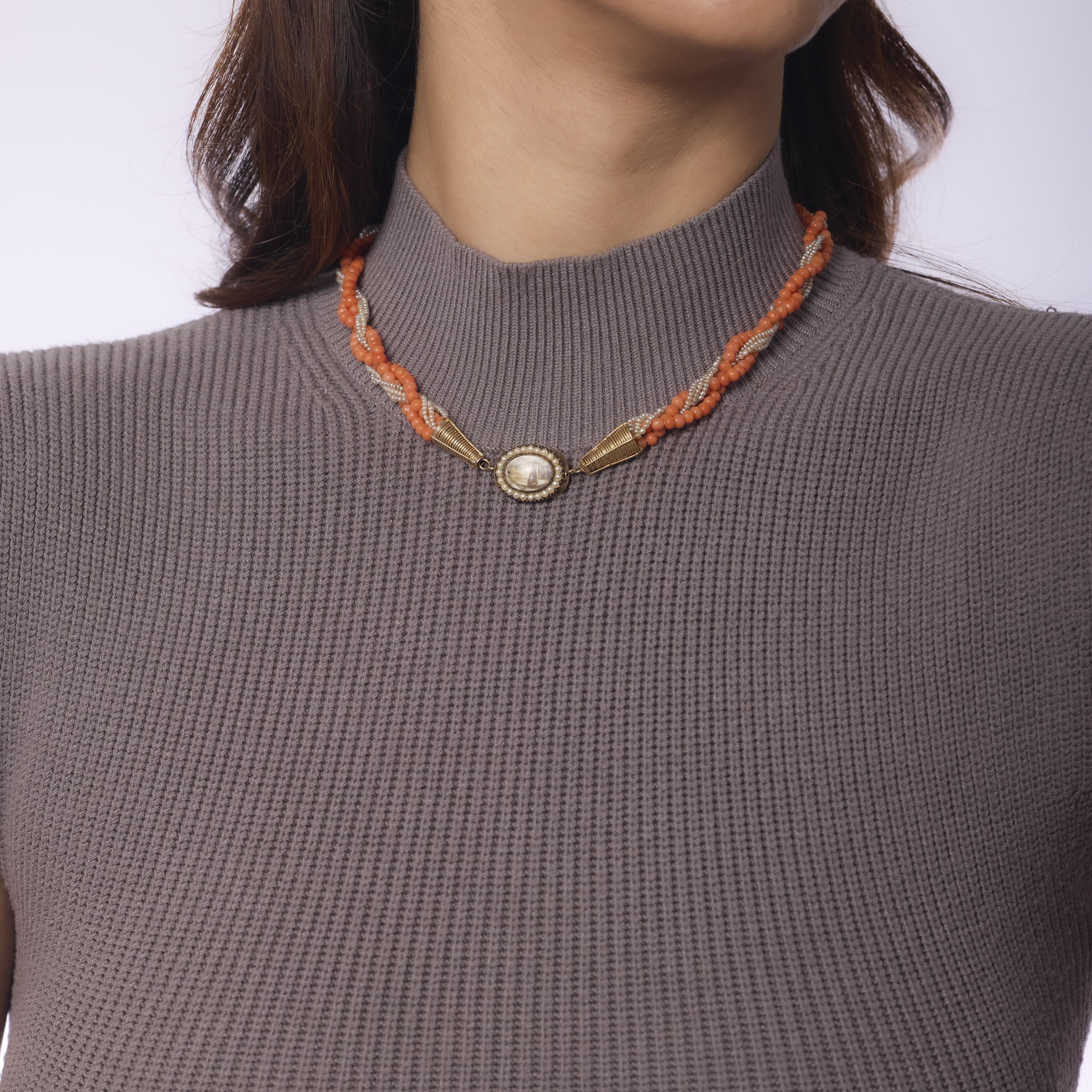 This antique 14k yellow gold mourning necklace showcases two luxurious strands of richly hued 3.60mm coral beads, gracefully joined by luminous seed pearl accents. Thoughtfully handcrafted in the 1880s, the necklace reflects the symbolic elegance of