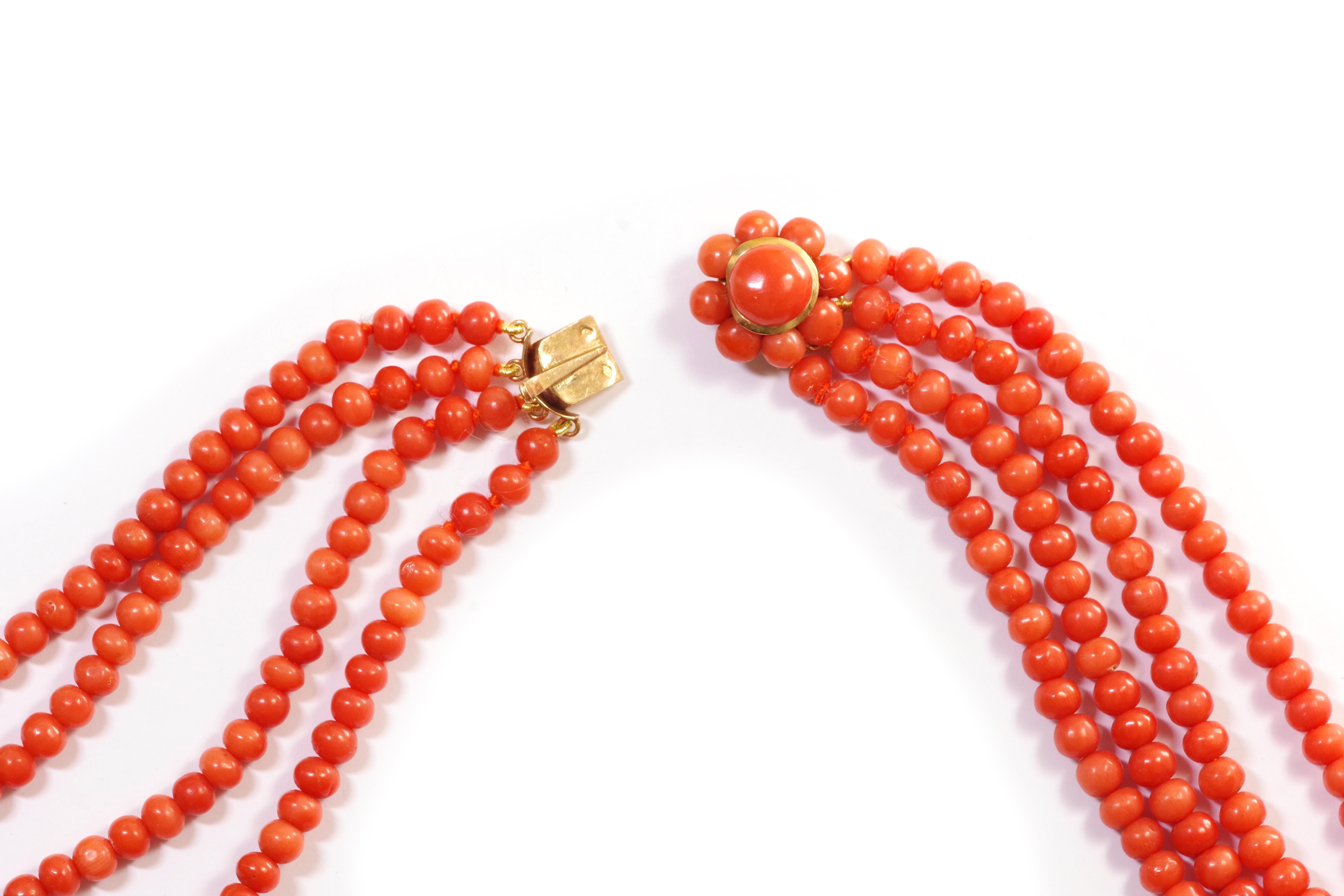 Antique mediterranean coral necklace. Four-strands coral necklace with flower clasp in 18k gold. Important necklace composed of four rows of Mediterranean coral pearls of the same diameter. The necklace's clasp takes the form of a flower adorned