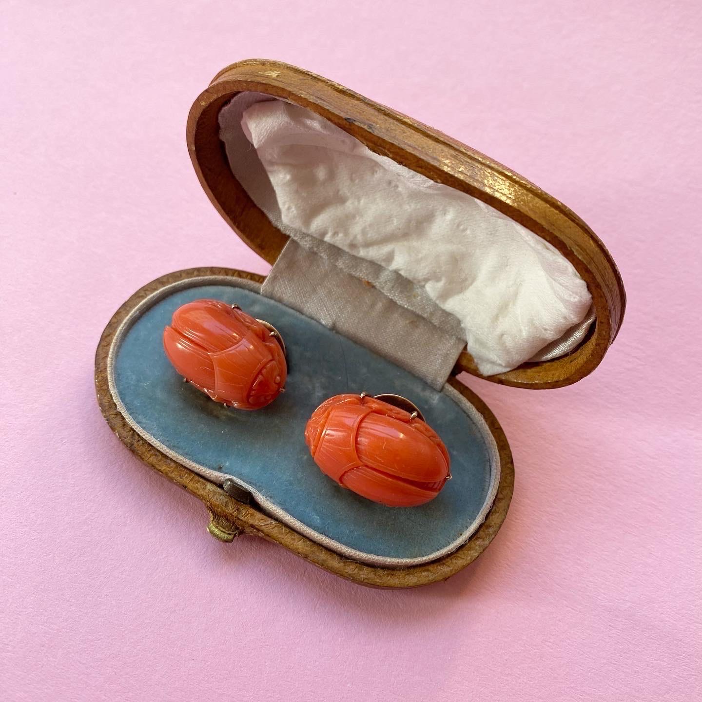 A pair of coral scarab cufflinks or studs with gold mountings in original case, England or Italy, 19th century.

weight: 14.4 grams
dimensions scarab: 2.4 x 1.5 cm