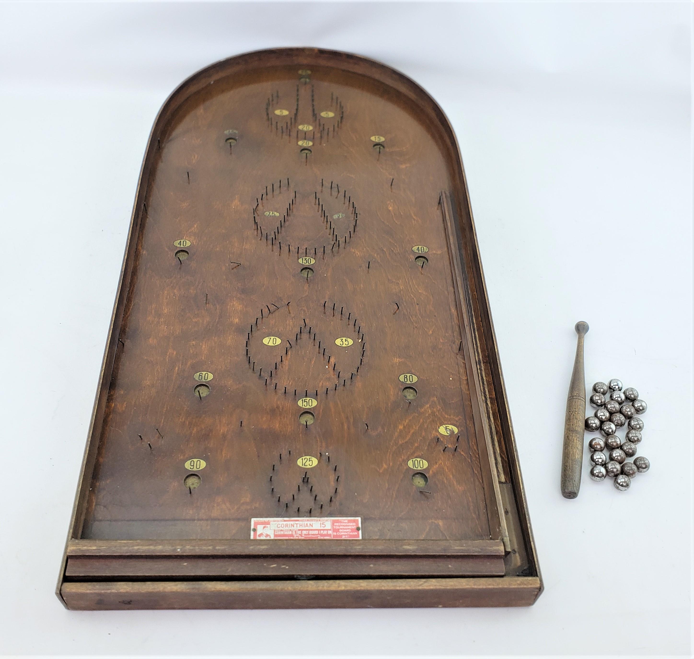 This antique bagatelle game set was made by the Corinthian Company of Finland in approximately 1920 and done in the period Art Deco style. The game board and bat are composed of walnut with a plywood base and bentwood surround. The set comes with