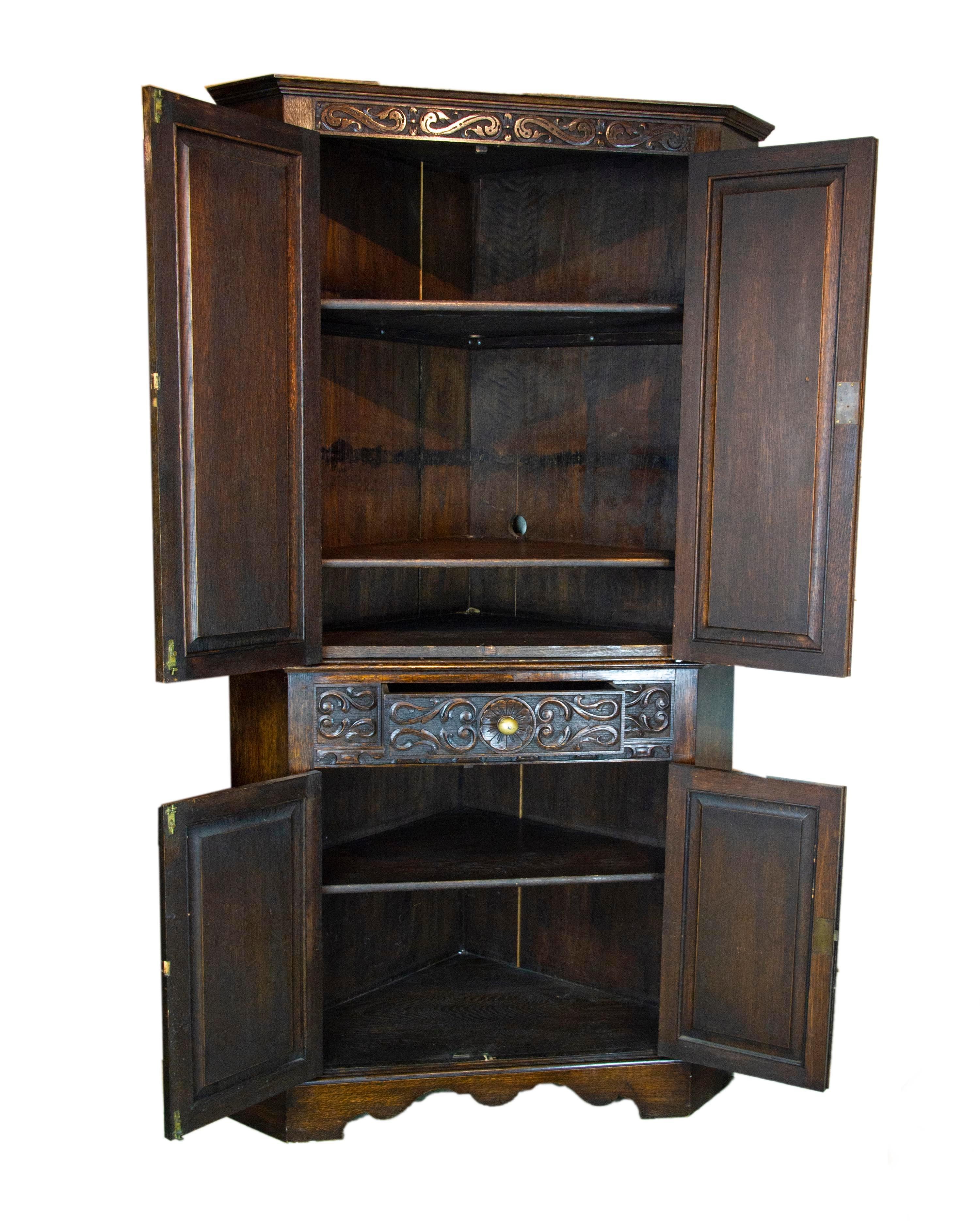 Antique corner cabinet, entryway decor, carved cabinet, Antique Furniture, Scotland 1950, B1497 

Scotland 1950
Solid oak construction
Original finish
Carved detailed cornice above
Pair of paneled doors below
Open to reveal two oak