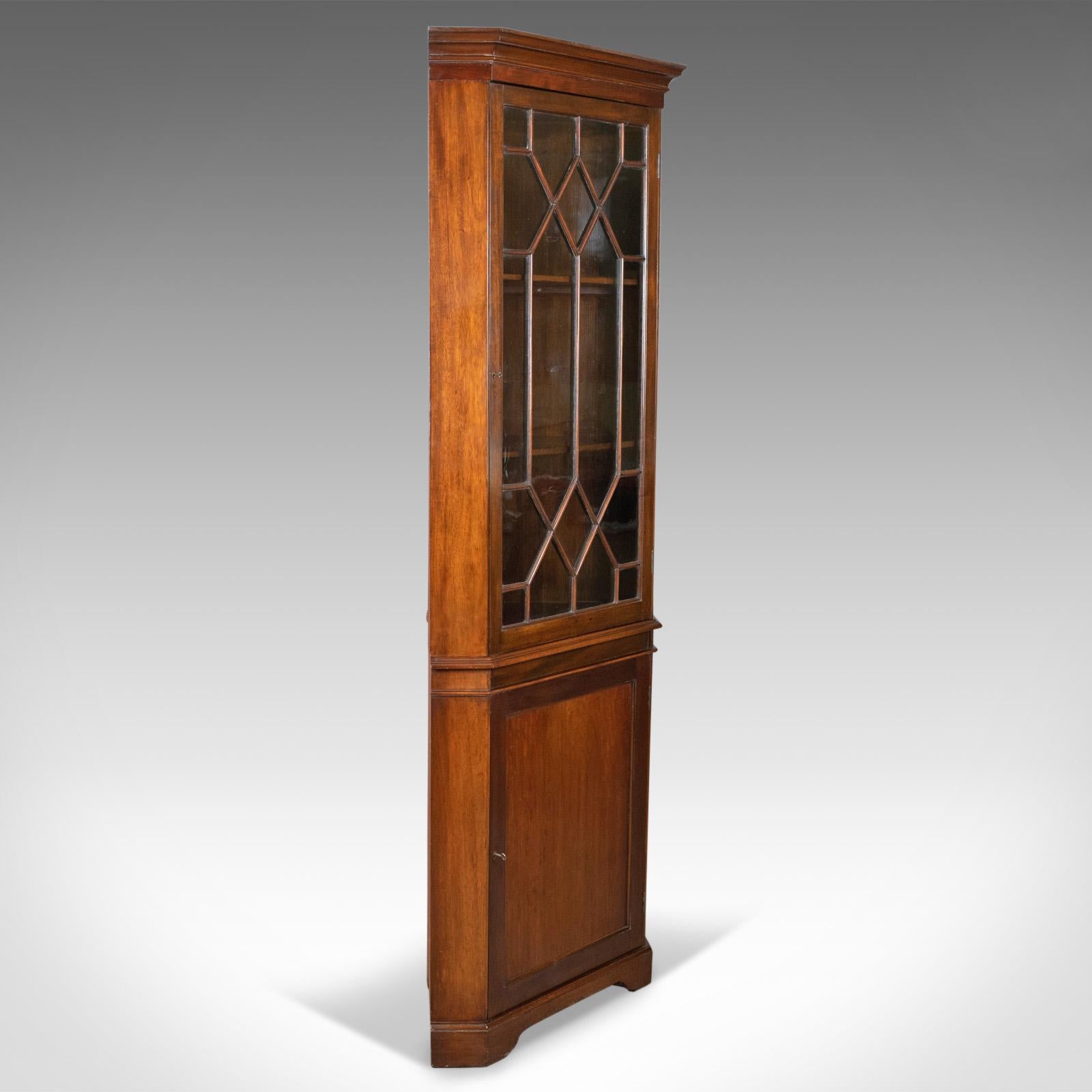 This is an antique corner cabinet, a glazed display cabinet, Edwardian in the Georgian Taste, English dating to circa 1910.

Mahogany with a deep rich lustre in the wax polished finish
Plain canted corners display grain interest beneath a modest