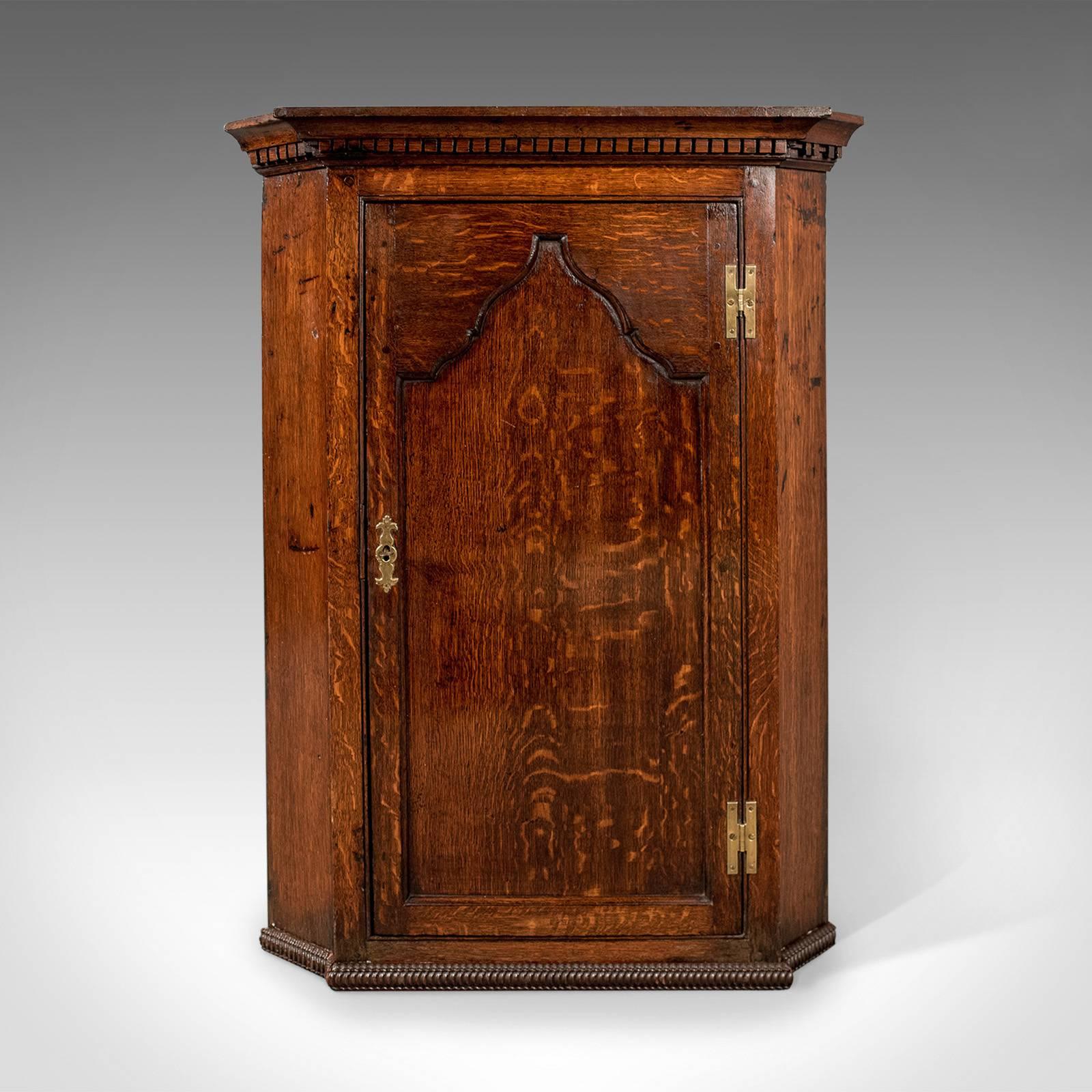 This is an antique corner cabinet, an English oak, late Georgian hanging cupboard dating to circa 1780.

Attractive deep tones to the oak with fine, consistent color
Attractive wisps of medullary rays prominent through the wax polished