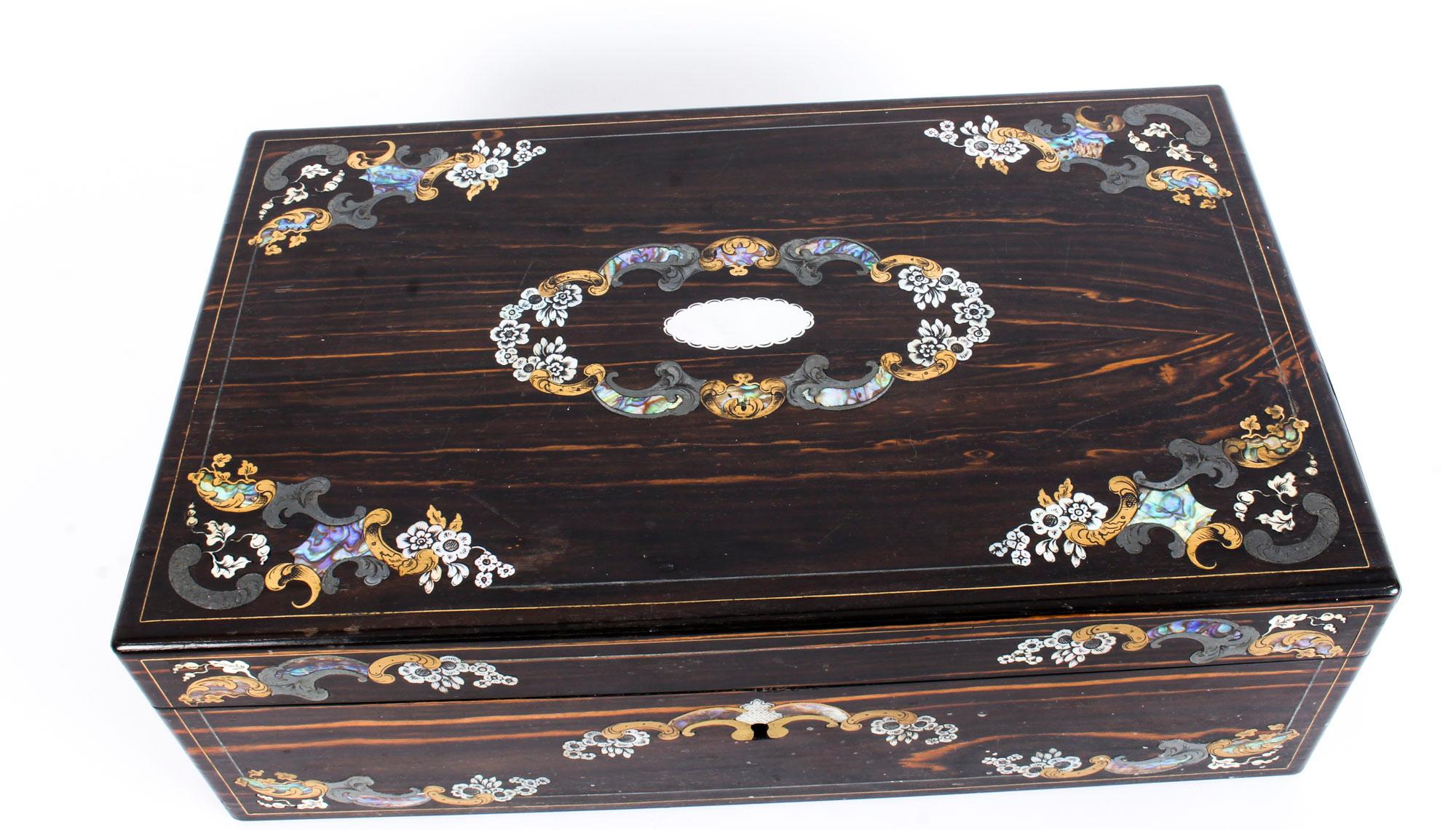 A lovely antique Victorian Coromandel writing slope, the Coromandel applied with beautiful inlaid decoration of brass, silver, bone and pewter, circa 1860 in date.

Opening to an interior desk with the original velvet lined writing slope, ink