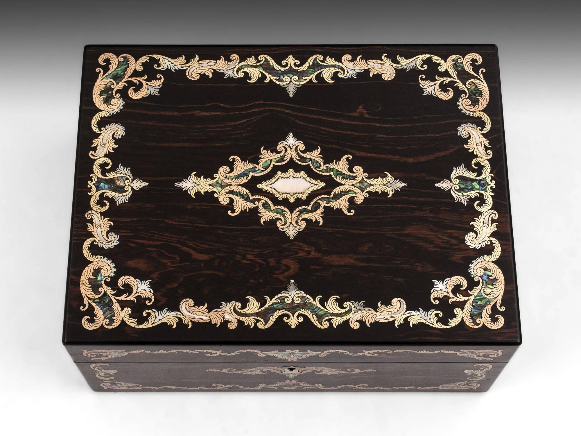 Antique jewelry box veneered in sumptuous coromandel and inlaid with an intricate combination of brass stringing, engraved brass, mother-of-pearl and abalone to the top and front. 

The interior of this eye catching sewing box lid has a mirror