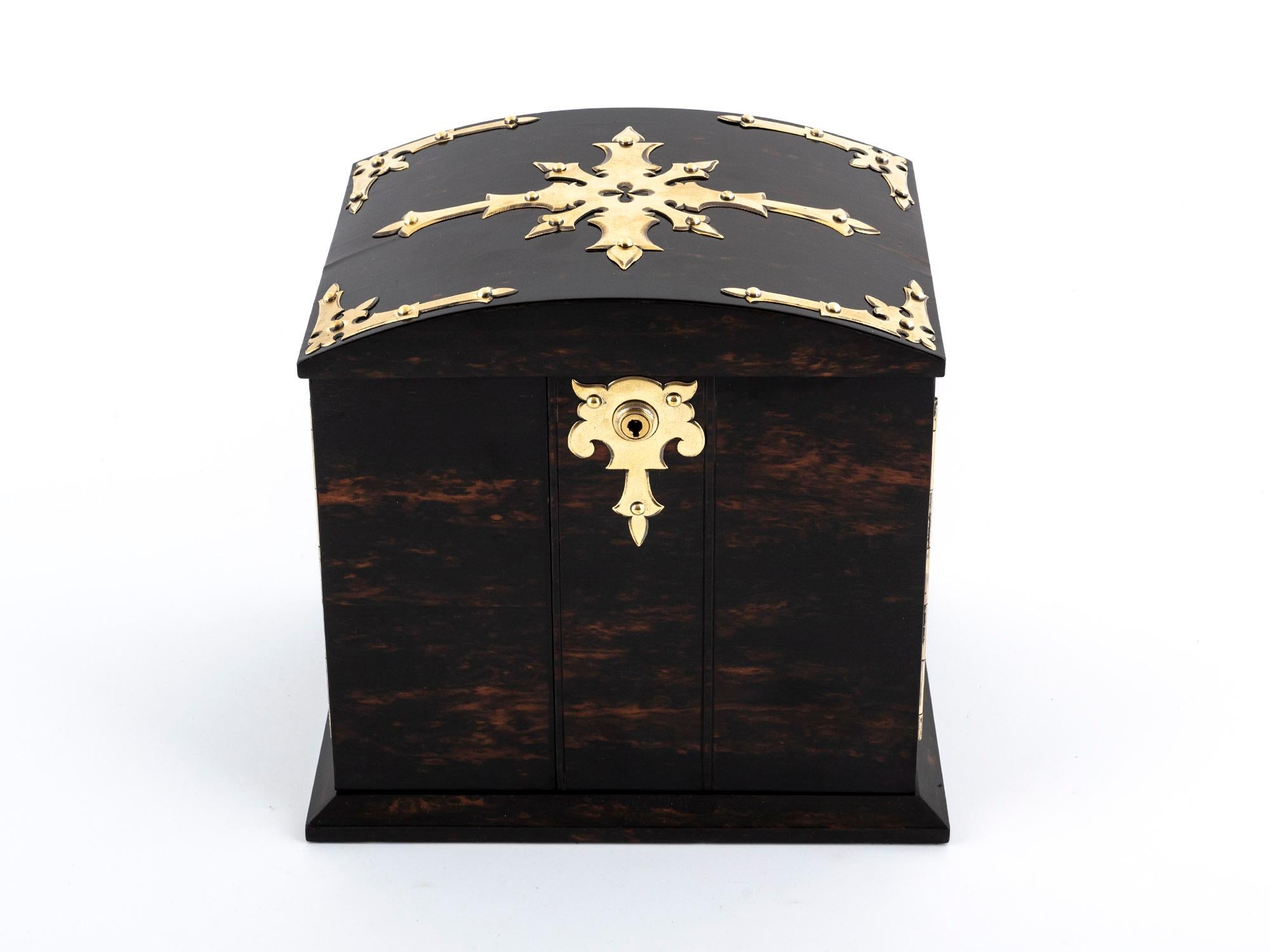 Discover this exquisite antique Coromandel Jewellery Cabinet by Betjemann & Son, an elegant, sophisticated work of art.

The dome-topped top is a distinguishing feature, and the intricate decorative inlay and fitted interior, coupled with brass