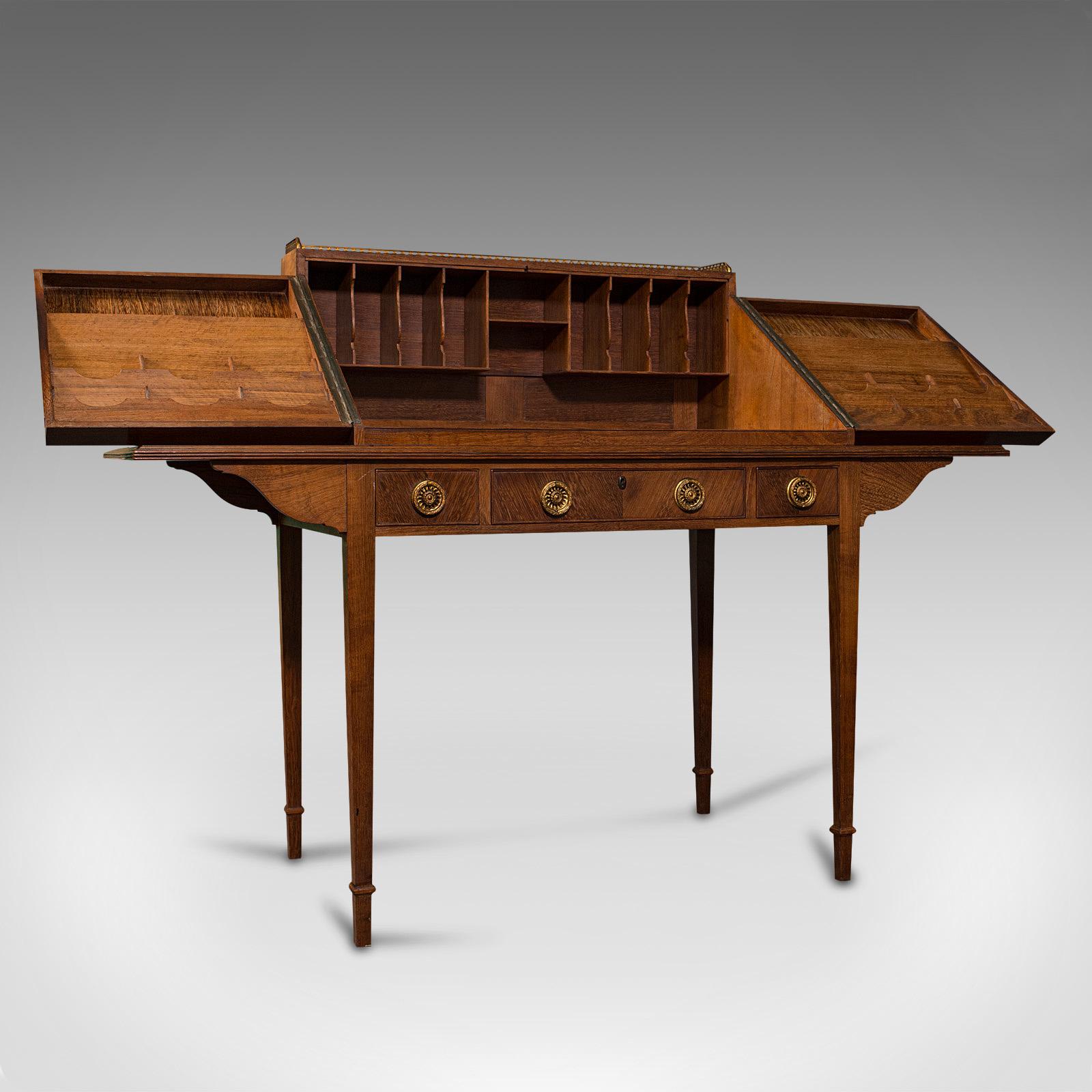 This is a vintage correspondence desk. An English, solid teak library or writing table in the manner of the Cotswold School, dating to the mid 20th century, circa 1950.

Strikingly figured desk of generous proportion and superb