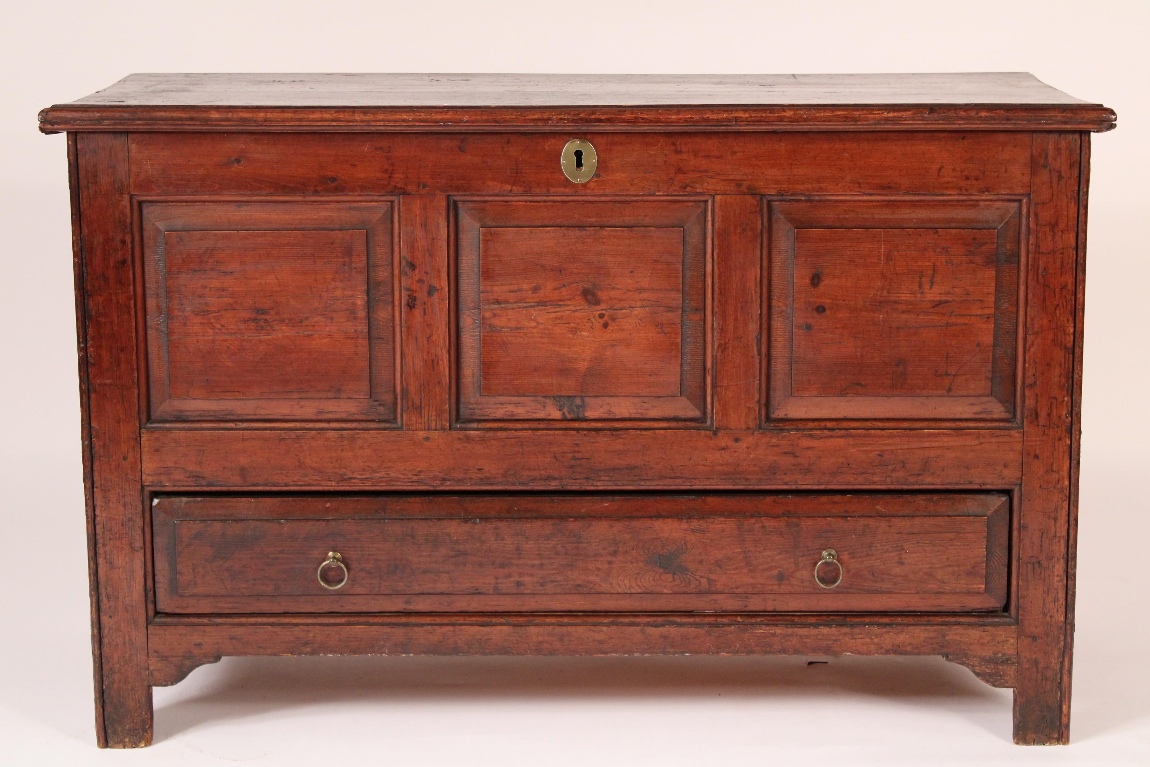 Country English pine trunk, 19th century. With a single board top with molded front and side edges, the front with 3 panels with chamfered edges, a bottom drawer, each side with 2 panels with chamfered edges, resting on square feet.