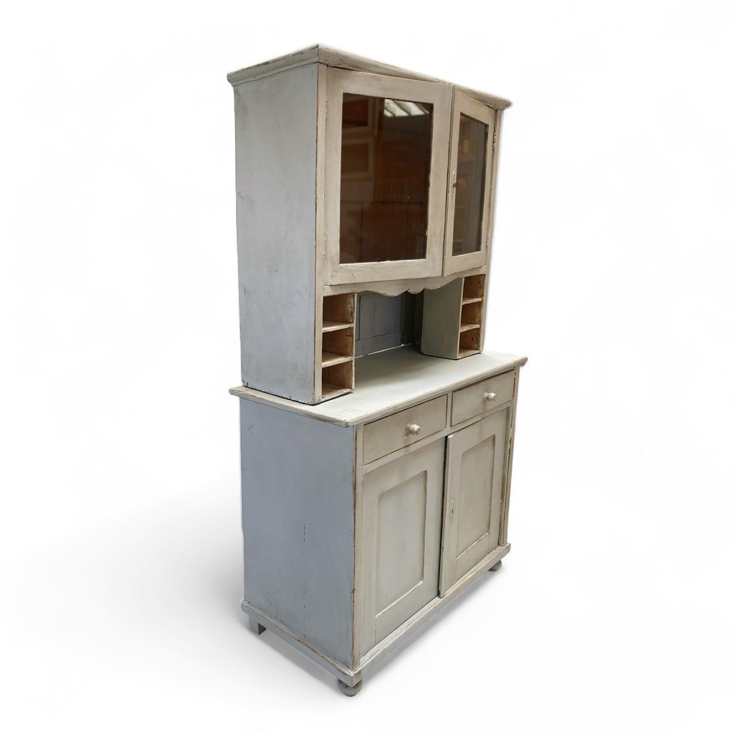 This country hutch is has a soft baby blue finish achieved through traditional milk-painting techniques, creating a beautifully aged patina that evokes a sense of history and warmth. Featuring charming vintage scalloped edges and stepback shelving