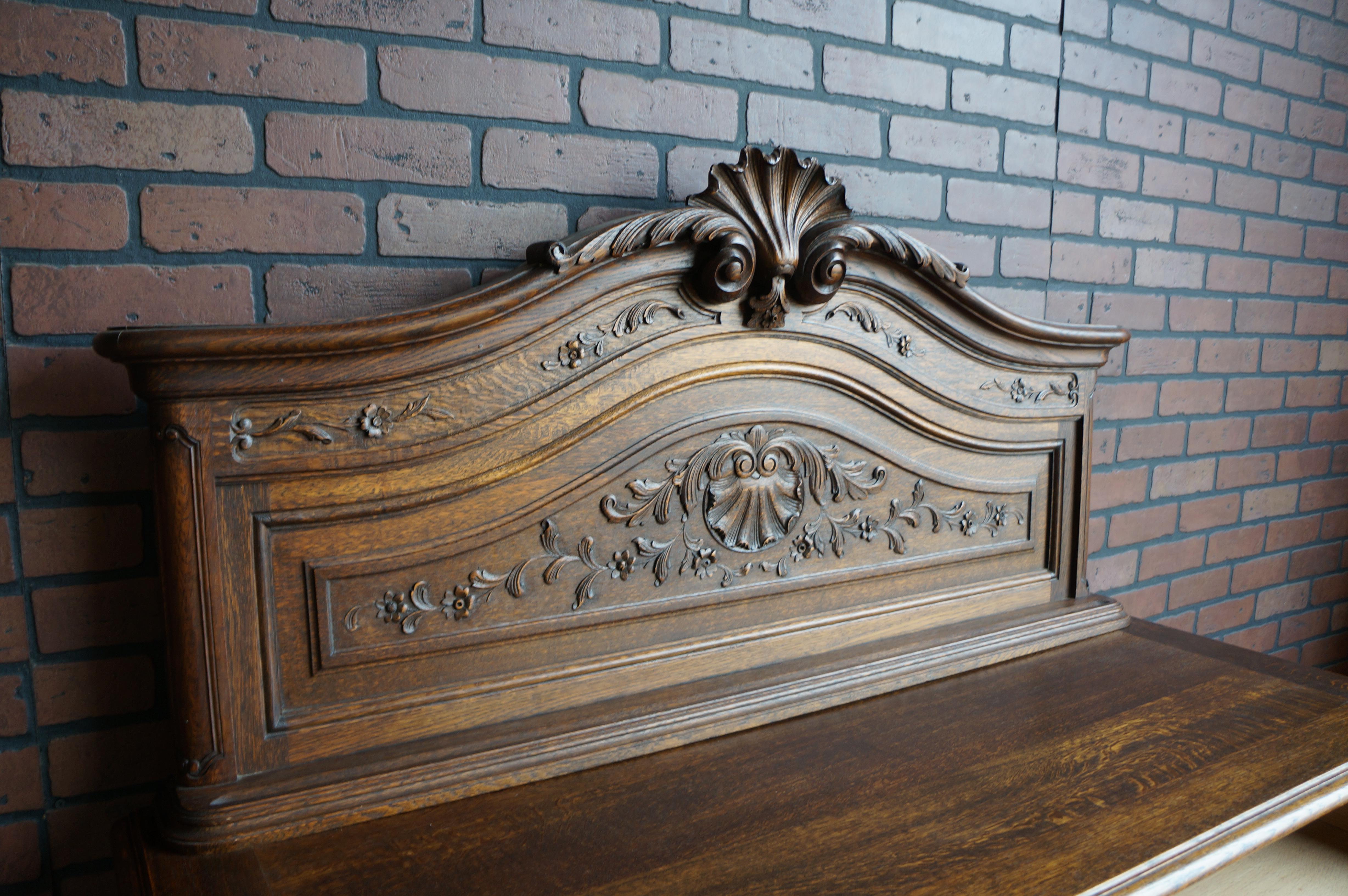 Remarkable French Country Oak Buffet. Exceptional carved details showcase fine craftsmanship. Featuring curvaceous raised door panels, scalloped apron and sweet cabriole legs. Love the back splash with shell pediment that is repeated in the shell