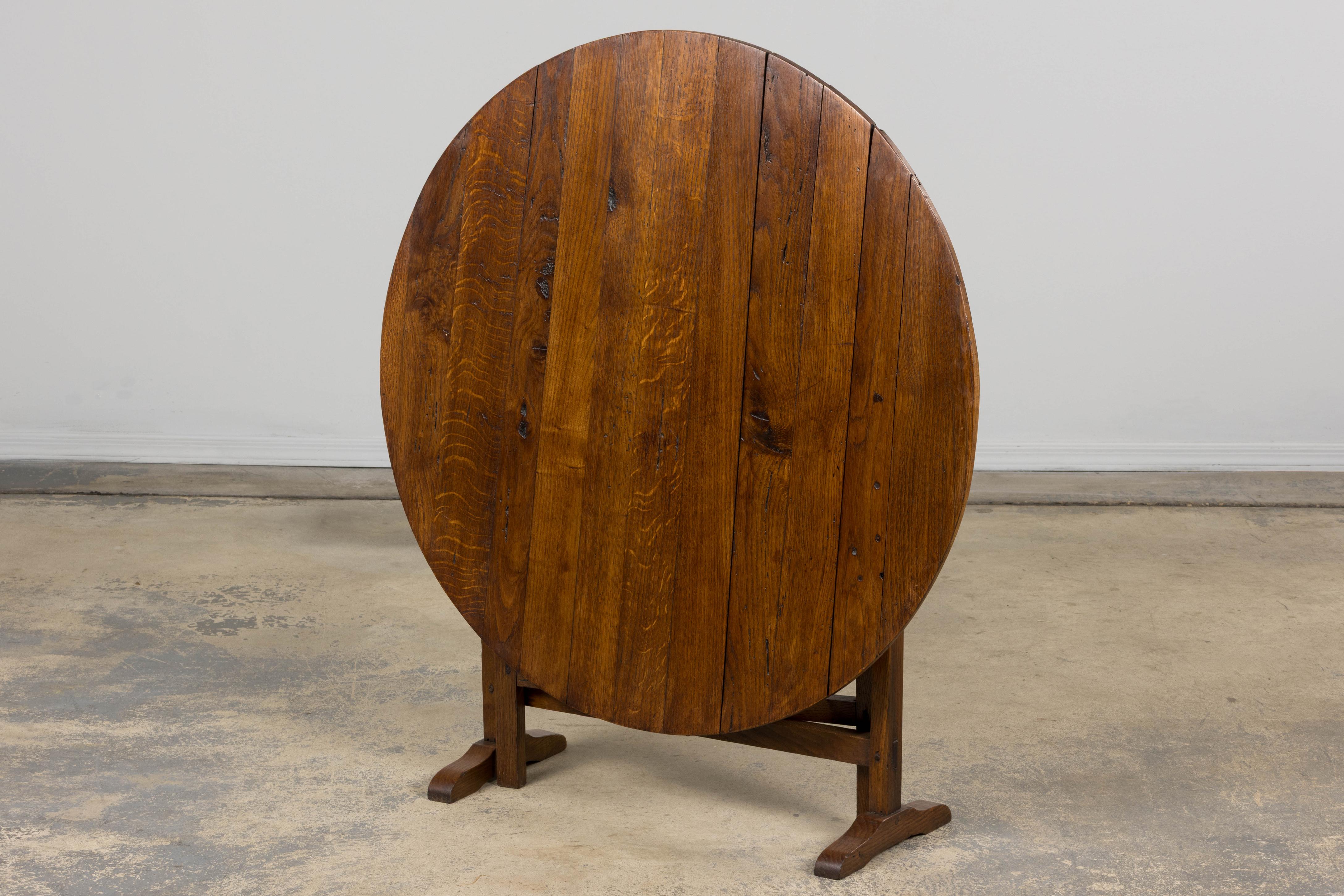 A charming mid 19th-century French Provincial vendange (wine tasting) table, sourced in Provence. Hand-crafted from solid oak, it features a distinctive off-round tilt-top measuring approximately three feet in diameter. The surface has been gently