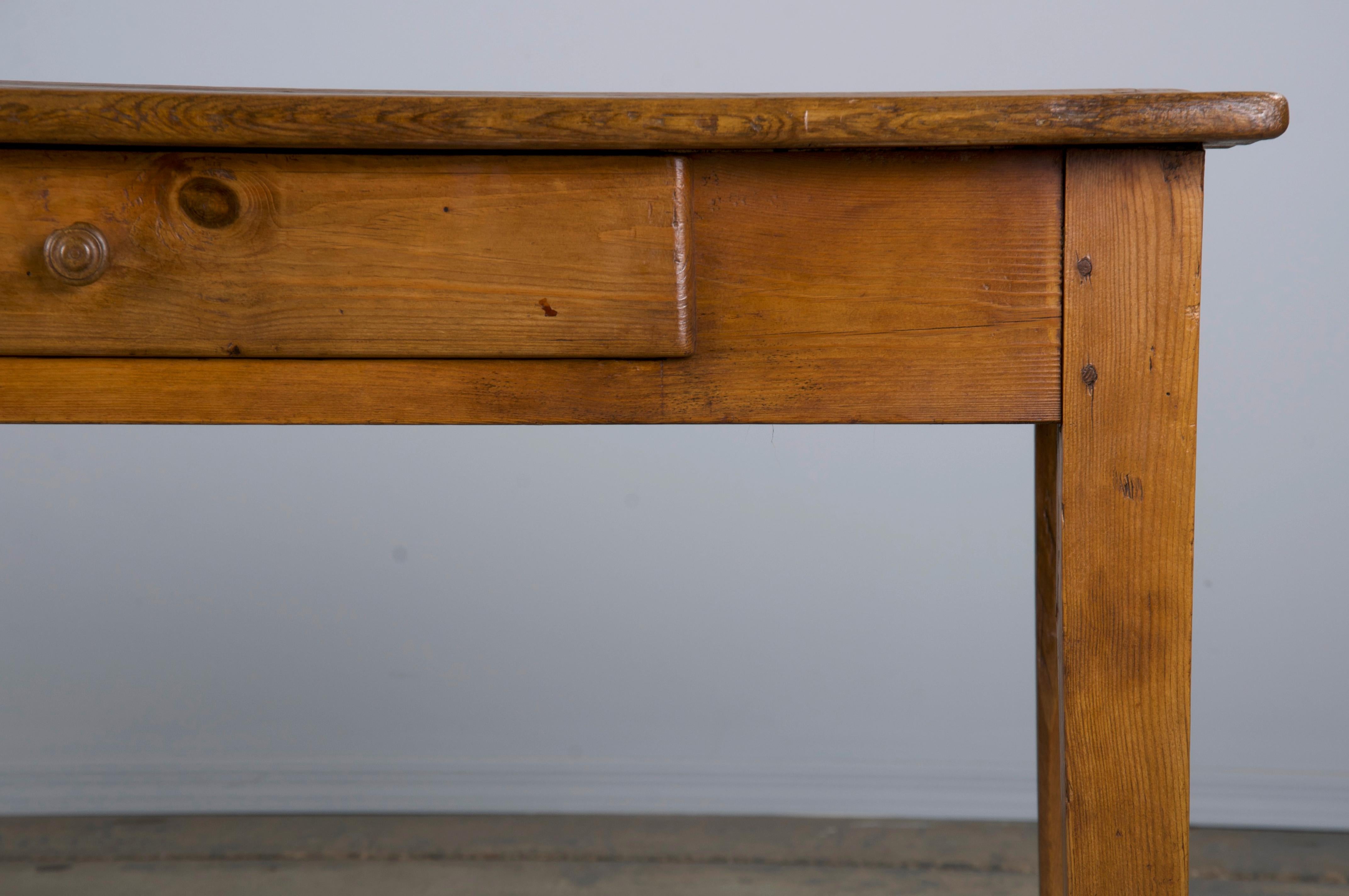 19th century country French farmhouse dining table, kitchen table, or desk sourced from Provence, France. Beautifully hand-crafted from solid European Pine featuring a 6'3