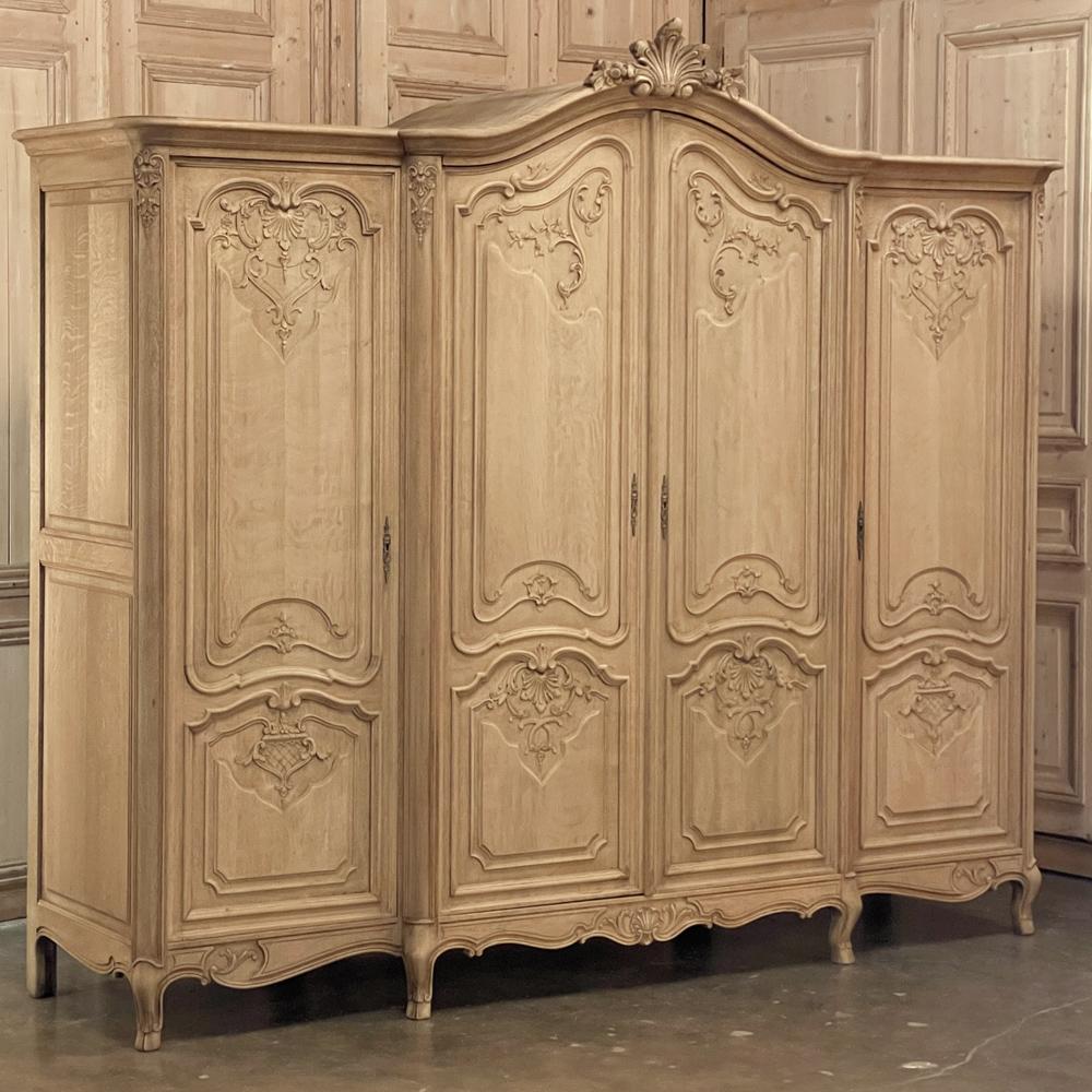 Antique Country French Four Door Armoire in Stripped Oak is a splendid choice for bedrooms with ceilings 8 to 9 feet in height! Four doors access three cabinet spaces for exceptional storage opportunities, while the top of the crest at the center is