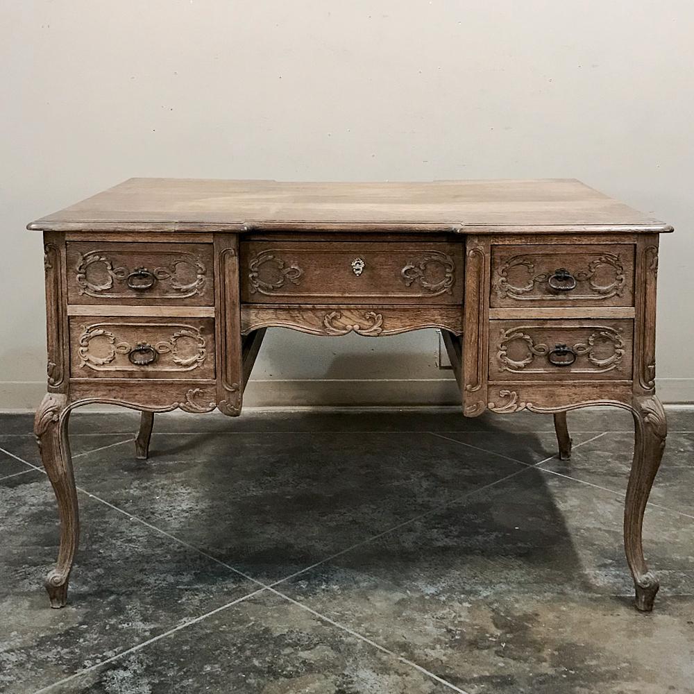 Antique country French Louis XV stripped oak desk was finished all around so it's perfect for placing in the center of the room! Finely sculpted molding detail combines with contoured top with recessed center section, cabriole legs, and brass drawer