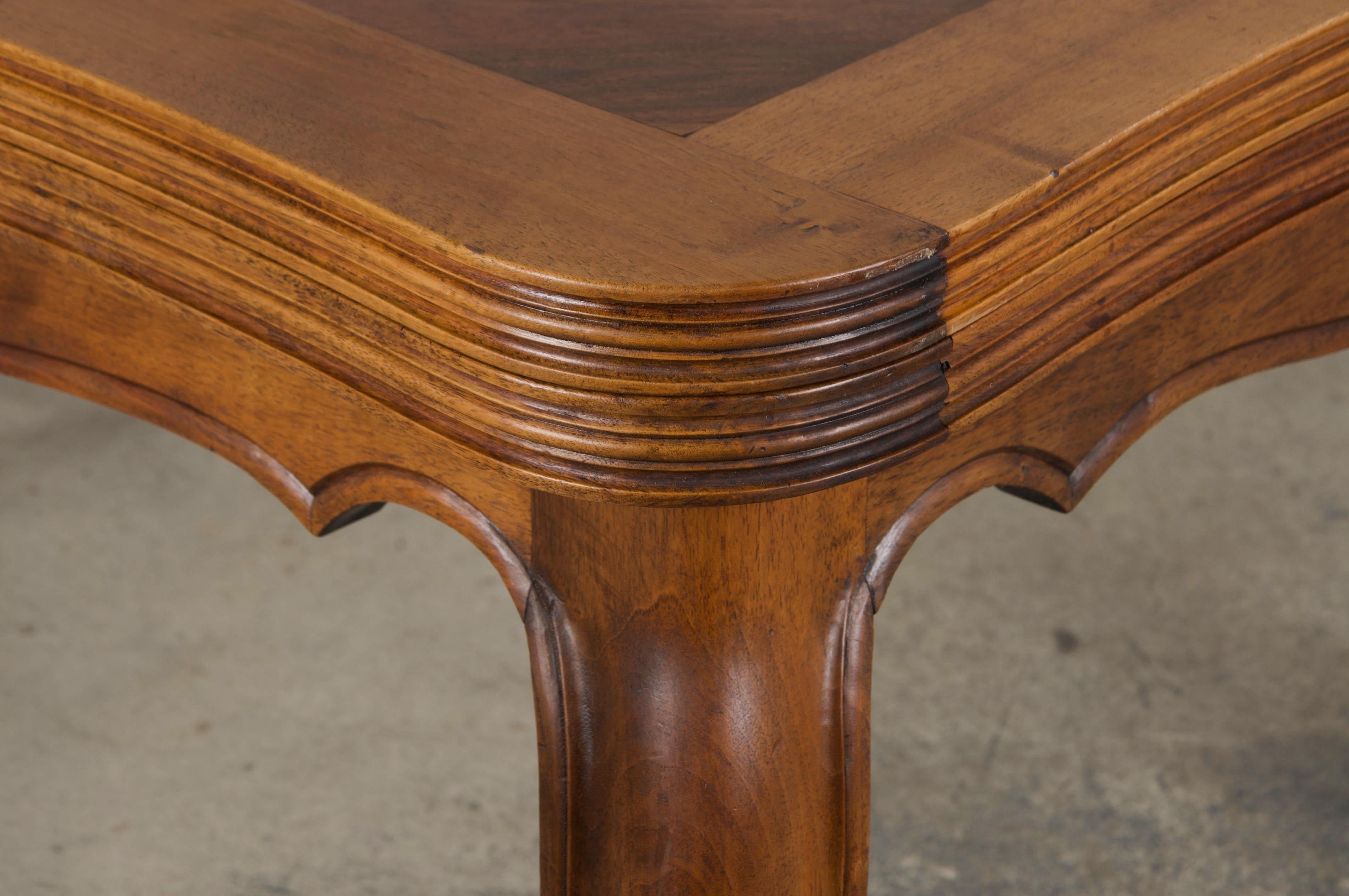 A traditional late 19th-century French Provincial dining table in the grand Louis XV style, sourced from Provence, France. Expertly handcrafted from solid walnut, the table has been structurally revised and professionally refinished to enhance its