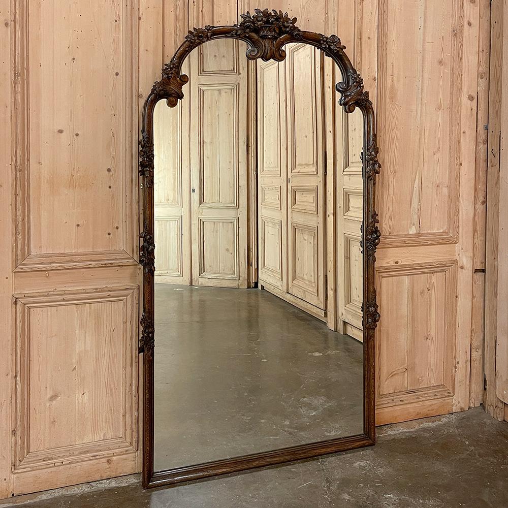 Der antike französische Louis-XVI-Spiegel mit Schnitzereien verfügt über einen prächtigen Rahmen, der von Hand aus massiver, altgewachsener Eiche in einer erstaunlichen Wiedergabe naturalistischer Schönheit geschnitzt wurde! Der doppelbogige Kranz
