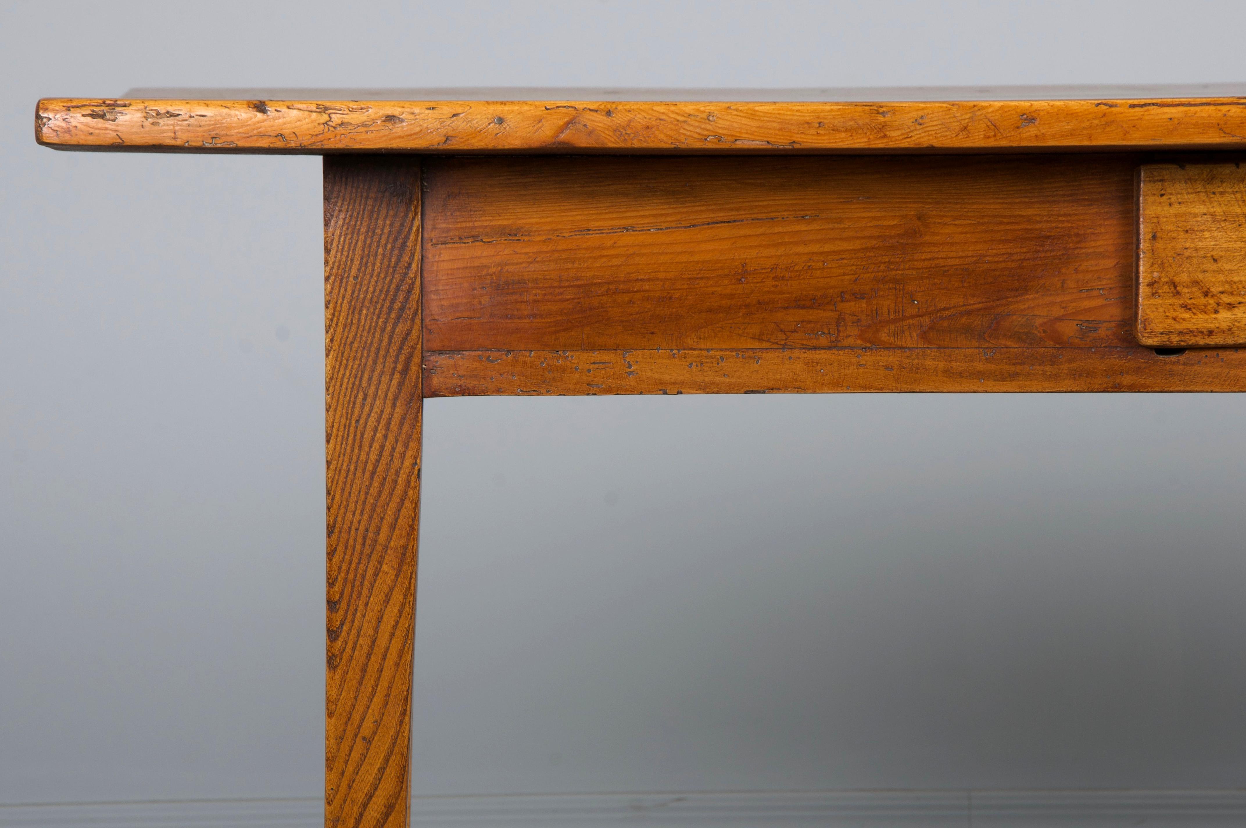 A rustic late 19th-century country French farmhouse table, sourced from Provence, France. Hand-crafted from solid wood, it features a 5.27-foot-long rectangular plank top made from beautifully aged European pine, full of natural character and warm
