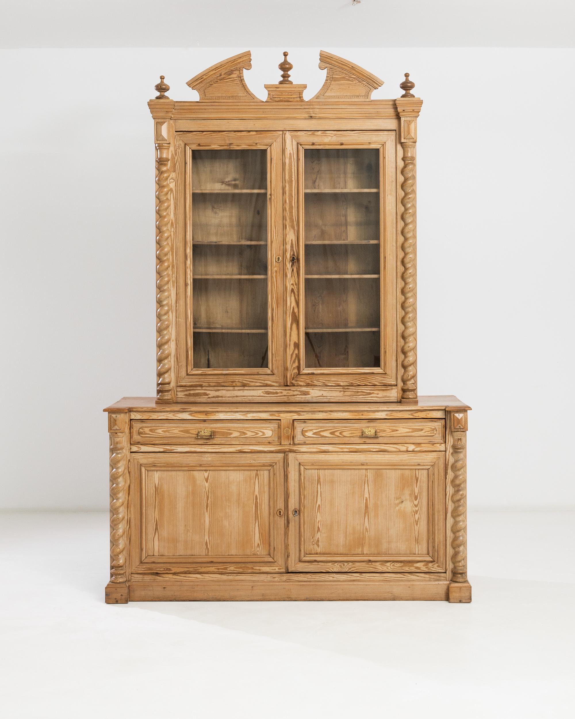 Built in France circa 1900, this fanciful country chest a deux corps boggles the imagination with its fine hand-carved ornamentation: spiral frames, delicate finials and the crown that forms a graceful half-arch on the top. The vitrine features an