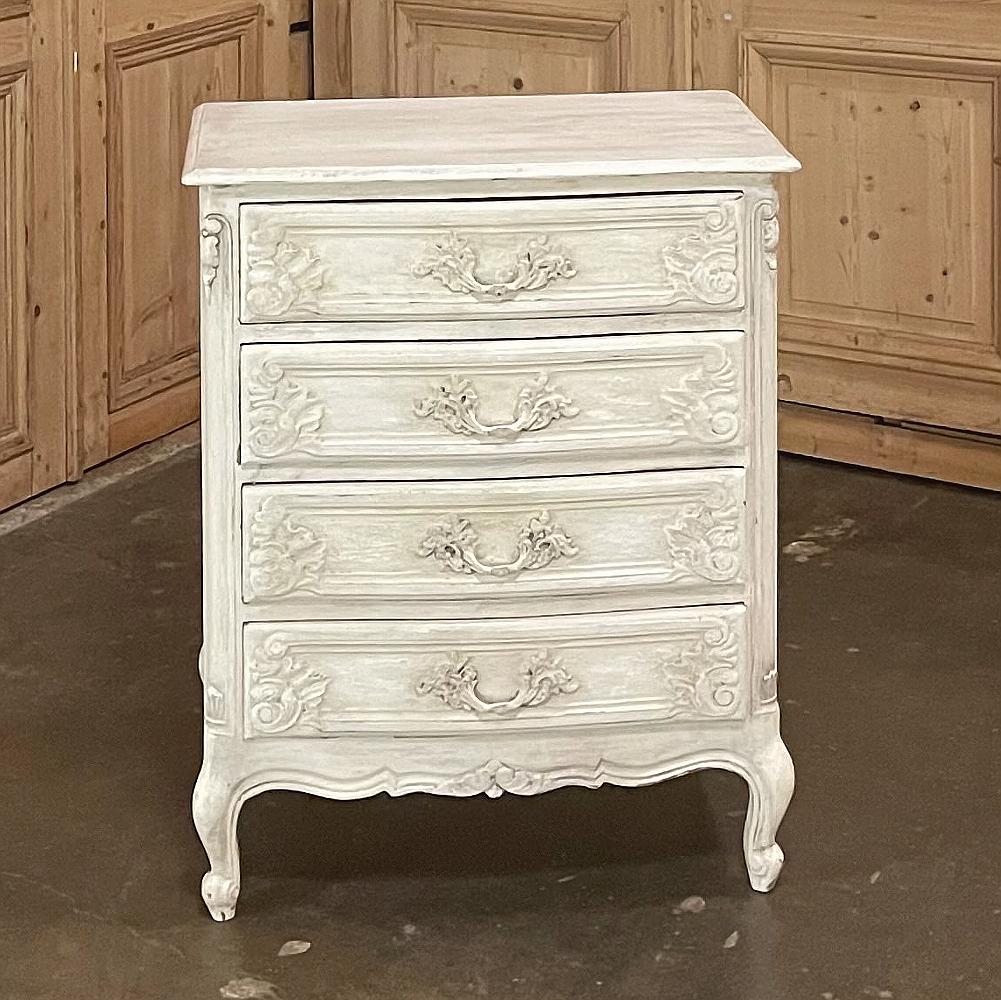 Antique Country French painted commode features a graceful appearance enhanced with subtle scrollwork from the carved ornamentation on the drawer facades to the four legs below, each tipped with esgargot carvings. The subtly scrolled apron has been