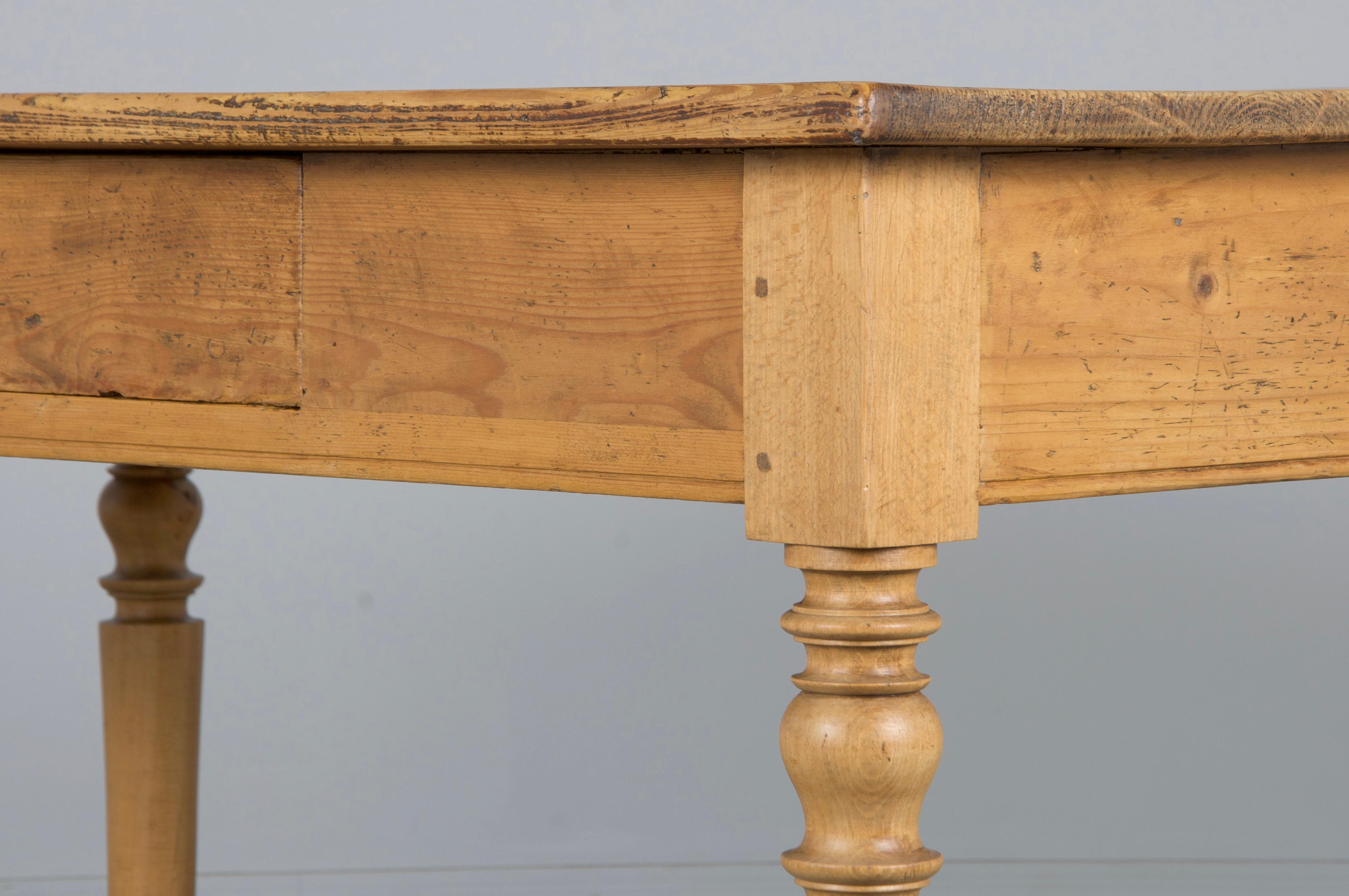 Encantador escritorio o mesita de comedor de la granja provincial francesa del siglo XIX, procedente directamente de la Provenza francesa. Hecha a mano con madera maciza de pino europeo rústico, tiene una tapa de tablones rectangulares de 1,8 m.
