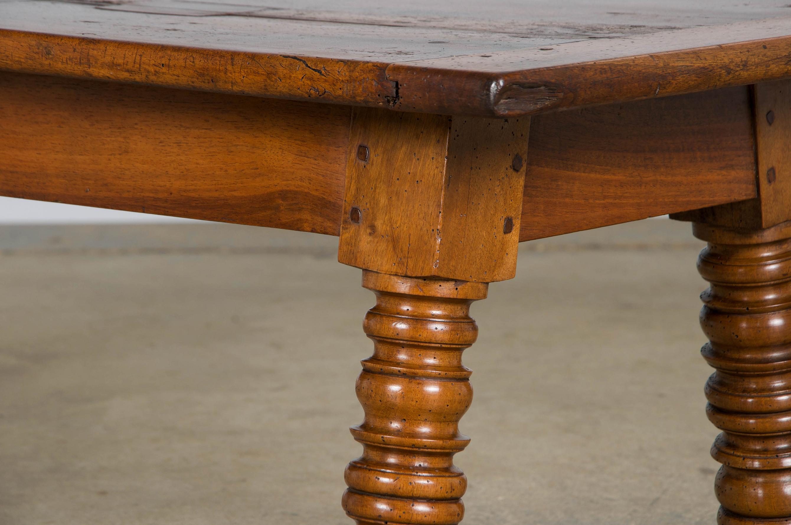 Charming mid-19th-century rustic country French provincial coffee table, sourced from Provence, France. Hand-crafted from solid walnut, it features a low profile and a 55-inch long rectangular plank top with breadboard ends, joined using traditional