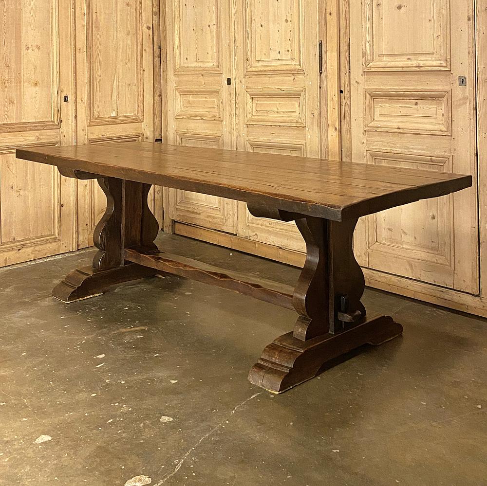 Antique country French Rustic trestle dining table was handcrafted from thick, solid timbers of old growth oak to literally last for centuries! The plank top rests on two very sturdy leg structures that tie into the top with a 