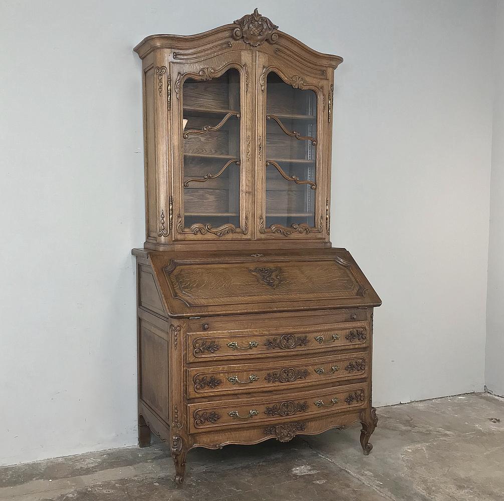 Antique Country French Secretary, bookcase is the perfect all-in-one solution! Handcrafted from solid oak to last for generations, it features an arched crown centered with a beautifully rendered crest, all presiding over the gracefully arched