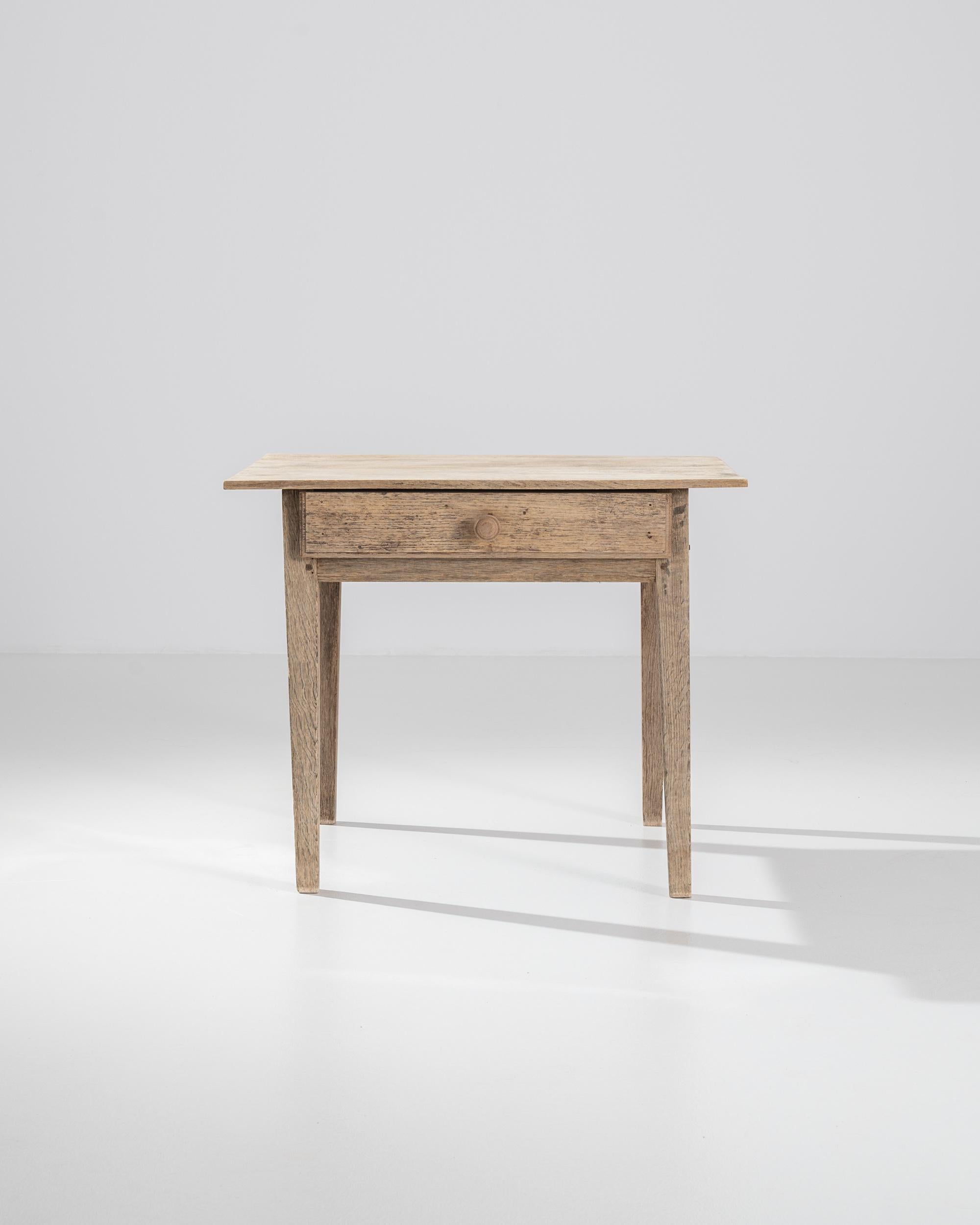 Crafted in France in the 19th Century, this oaken table has managed to capture the essential charm of necessity. Rather than the perfection of machine made geometry, this handmade piece stands with the swagger of authenticity, rejecting the