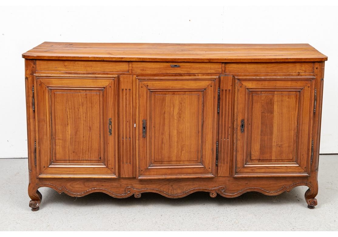 Early to mid 19th c. from La Vendee or Charante region of France in both Louis XV and XVI styles.  An elegant enfilade with dowel construction.  A narrow apron with a single center drawer (lacking a key). With Louis XVI carved fluted supports and