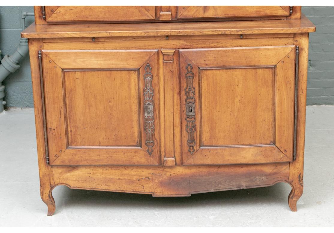 The tall two- part cabinet with carved cornice over the top with double grille doors with fine iron mount, two shelves inside. The lower cabinet with double doors opening to one shelf, both sections with fine iron mounts (with keys). Raised on