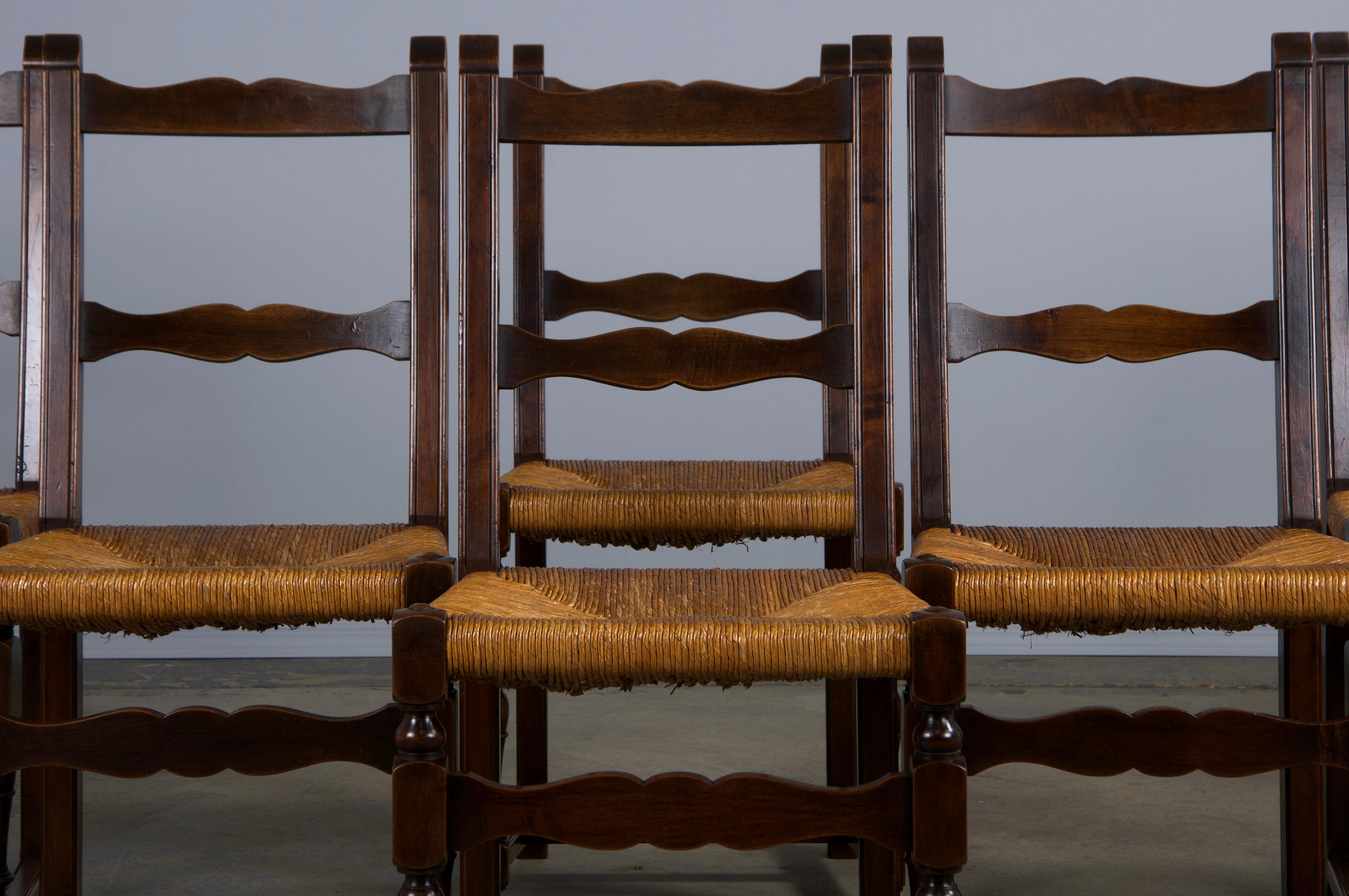 Un affascinante set di otto sedie da pranzo francesi del XIX secolo, provenienti direttamente dalla Provenza. Intagliate a mano in noce massiccio, queste sedie presentano un elegante design con schienale a scaletta e vantano una patina naturale