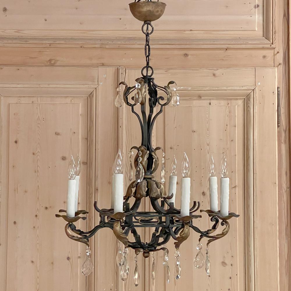 Antique Country French wrought iron and crystal chandelier is a splendid work of the blacksmith's art! The central hoop design with a double tier connected with gold accented ovals supports the scrolled arms that support the piecrust bobeches and