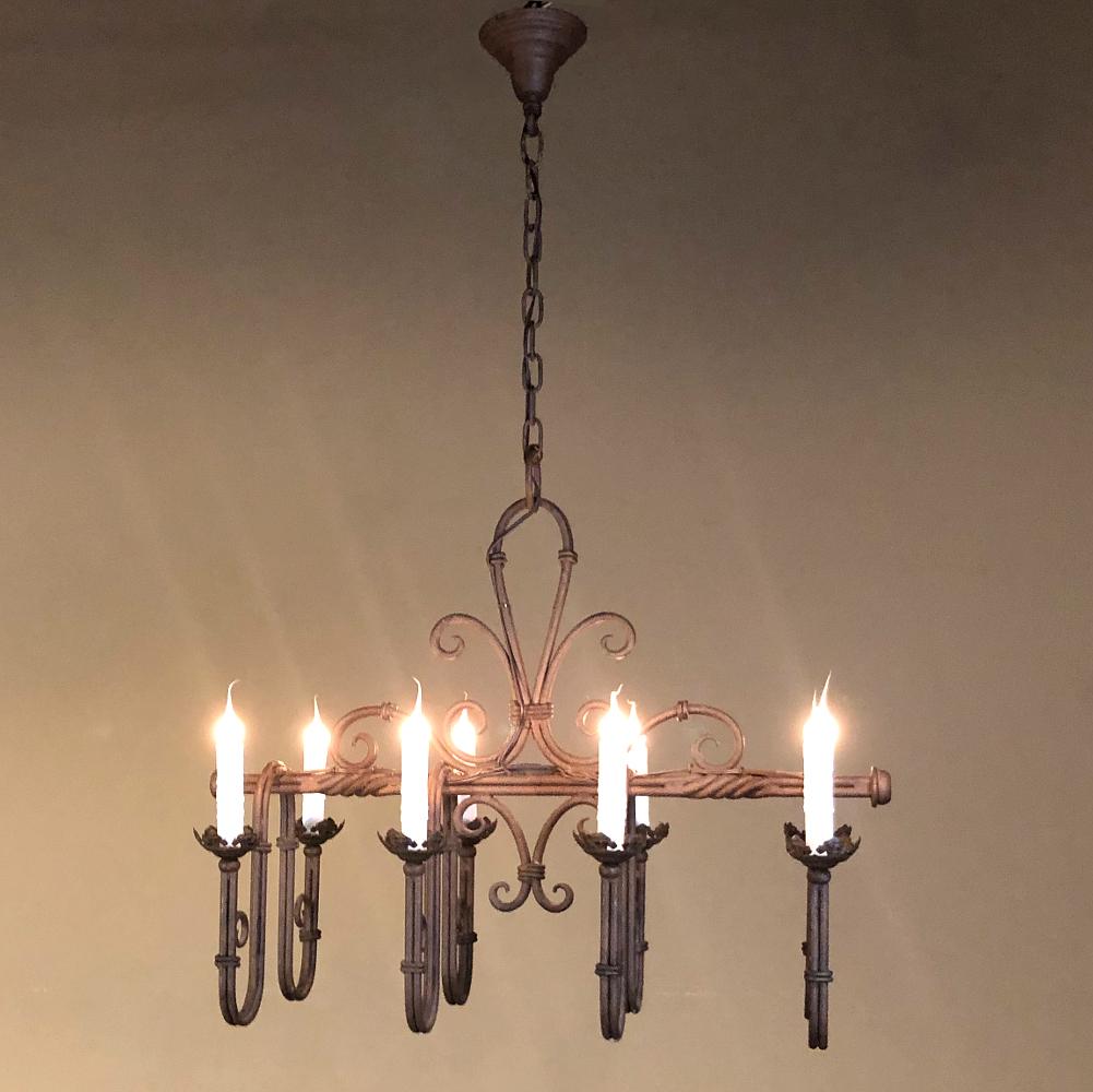 Antique Country French wrought iron chandelier is a timeless design, featuring a prominent fleur de lys taking center stage! A substantial length of original chain with canopy survives, making it flexible for mounting height by removing links as