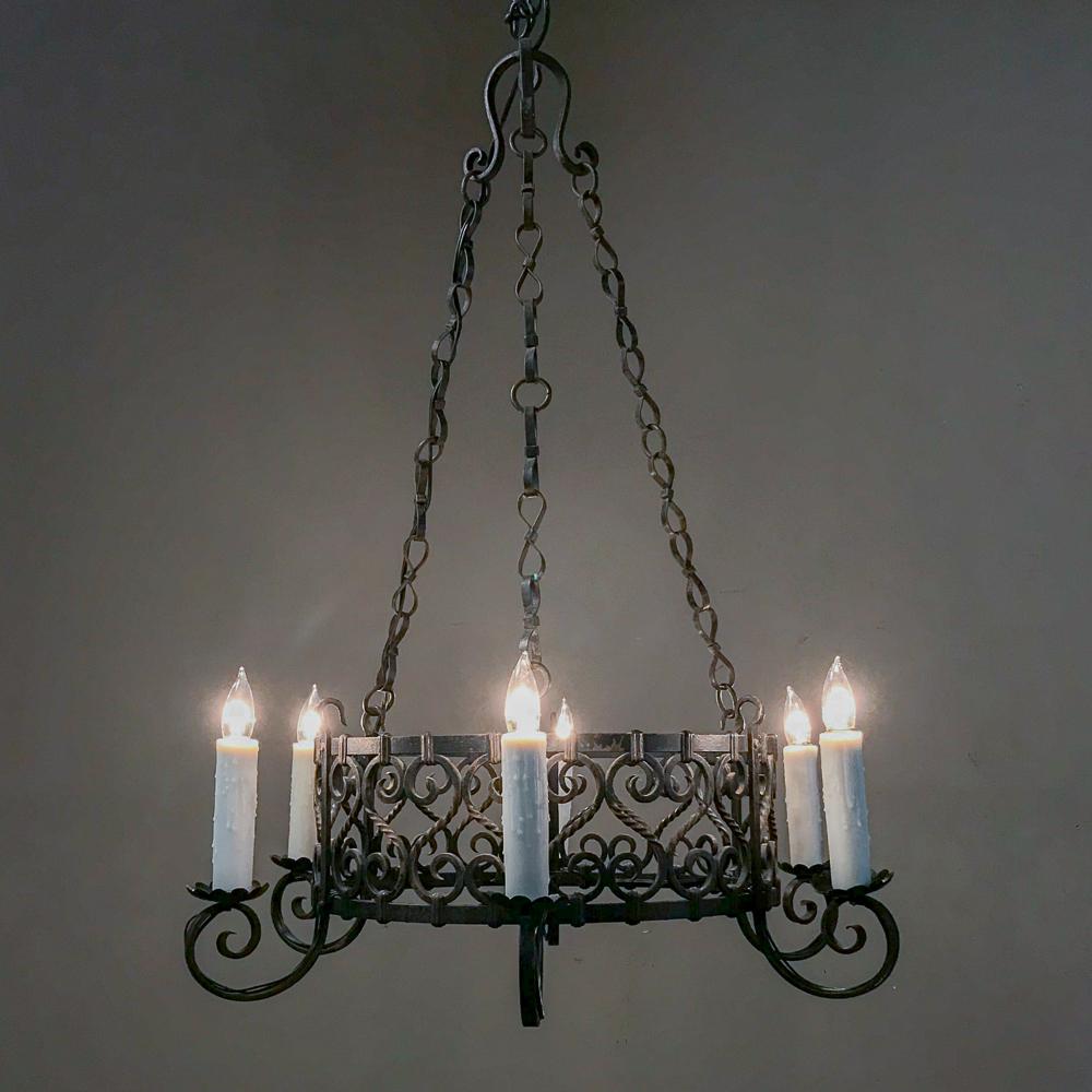 Antique country French wrought iron chandelier features subtle artistry in the craftsmanship that belies the difficulty in creating the spiralled rods and scrolled embellishments.
Price includes new standard electrification!
circa early