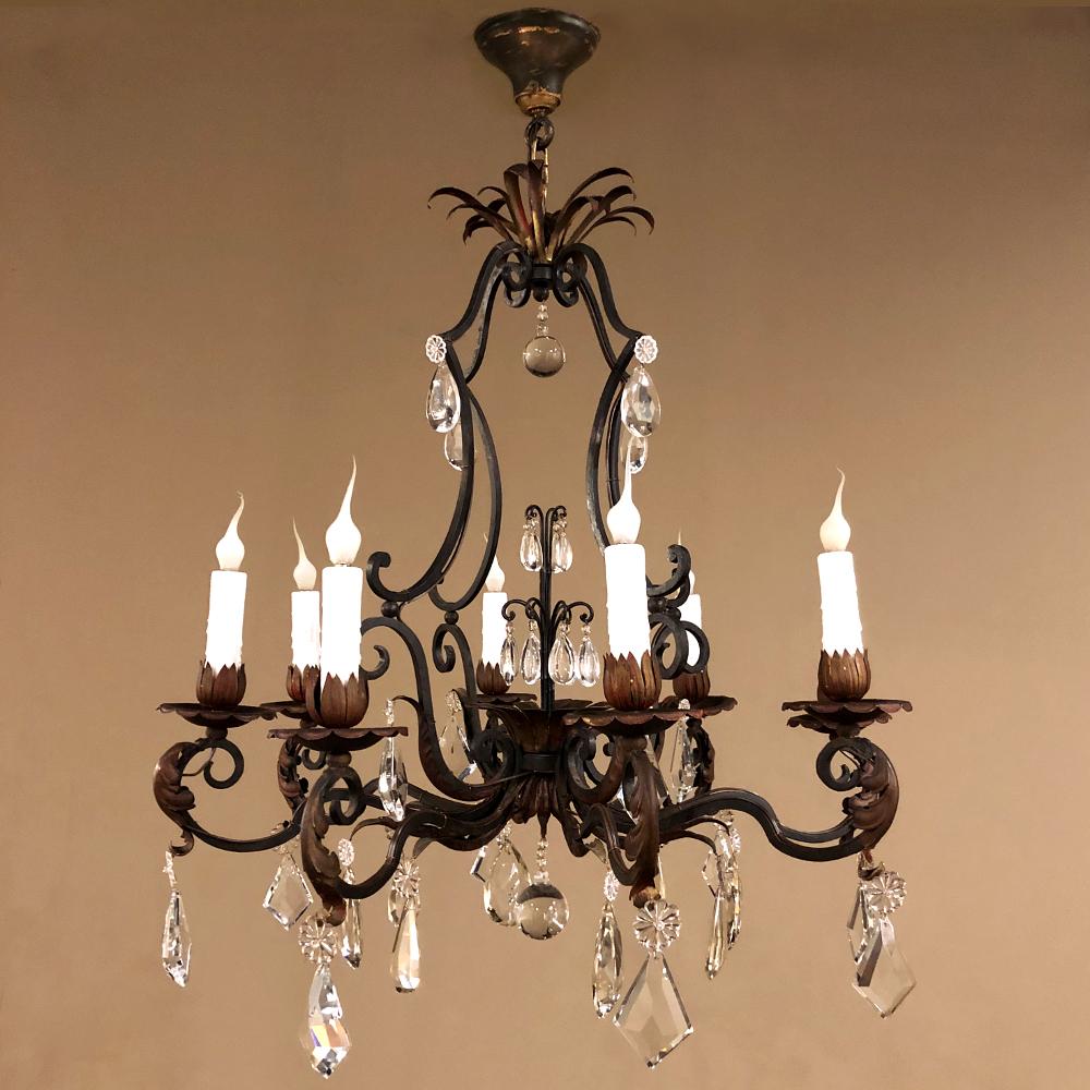 Antique Country French wrought iron & crystal chandelier combines the best of both design worlds! A casual elegance has been created from hand-forged wrought iron by an obviously capable metal smith, with a finely contoured framework forming the