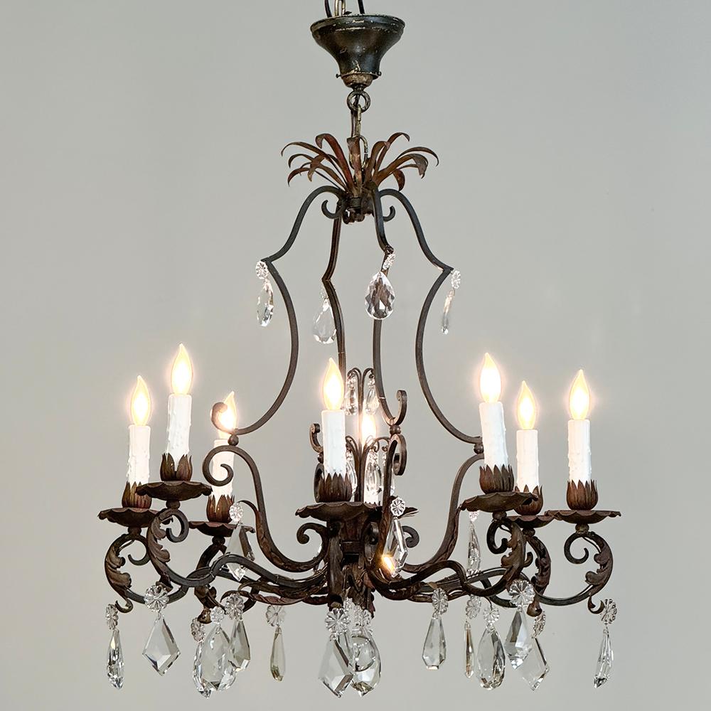 Antique Country French wrought iron & crystal chandelier combines the best of both design worlds! A casual elegance has been created from hand-forged wrought iron by an obviously capable metal smith, with a finely contoured framework forming the