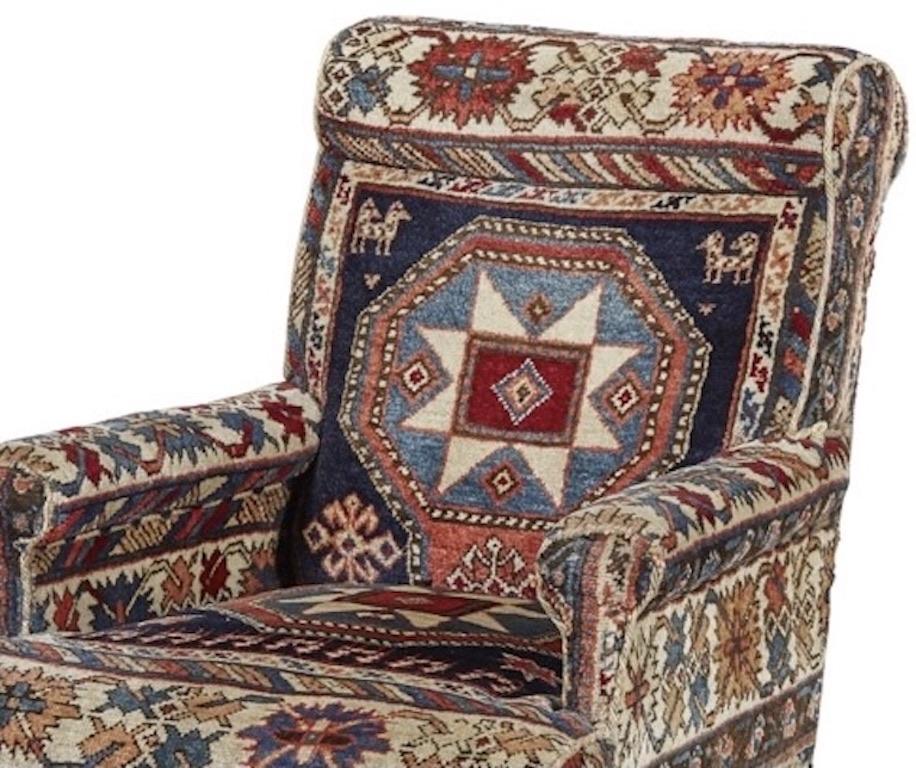 An absolutely beautiful, comfortable armchair that would be a stunning addition to any home. 
The square back above a stuff over seat and enclosed arms.
Very rare and fine example, wonderful bright colours with original kilim.
Raised on tapered