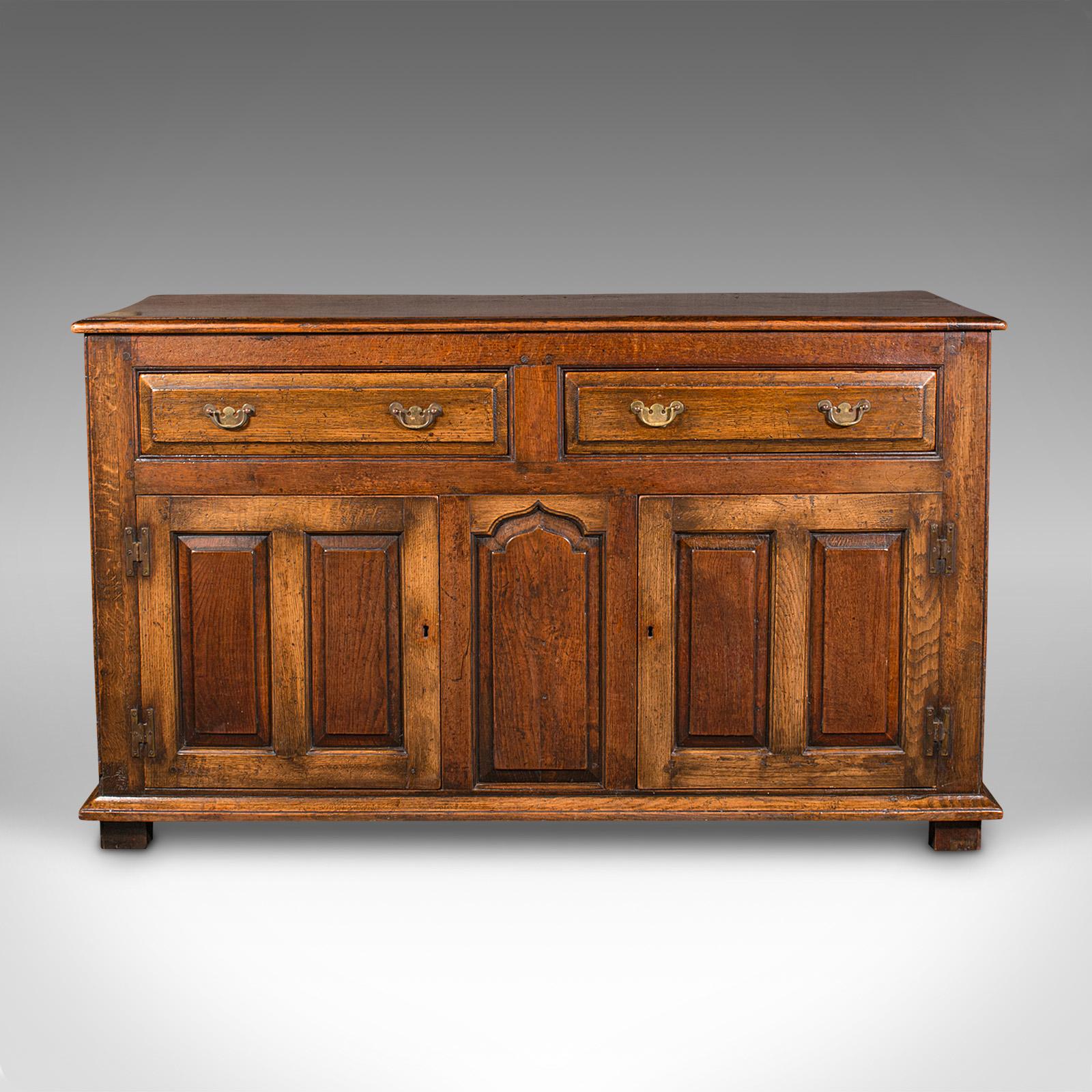 This is an antique country housekeeper's cabinet. An English, oak and elm dresser base, dating to the Georgian period, circa 1800.

Wonderful Georgian cabinetry with appealing proportion
Displays a desirable aged patina and in good order
Select oak