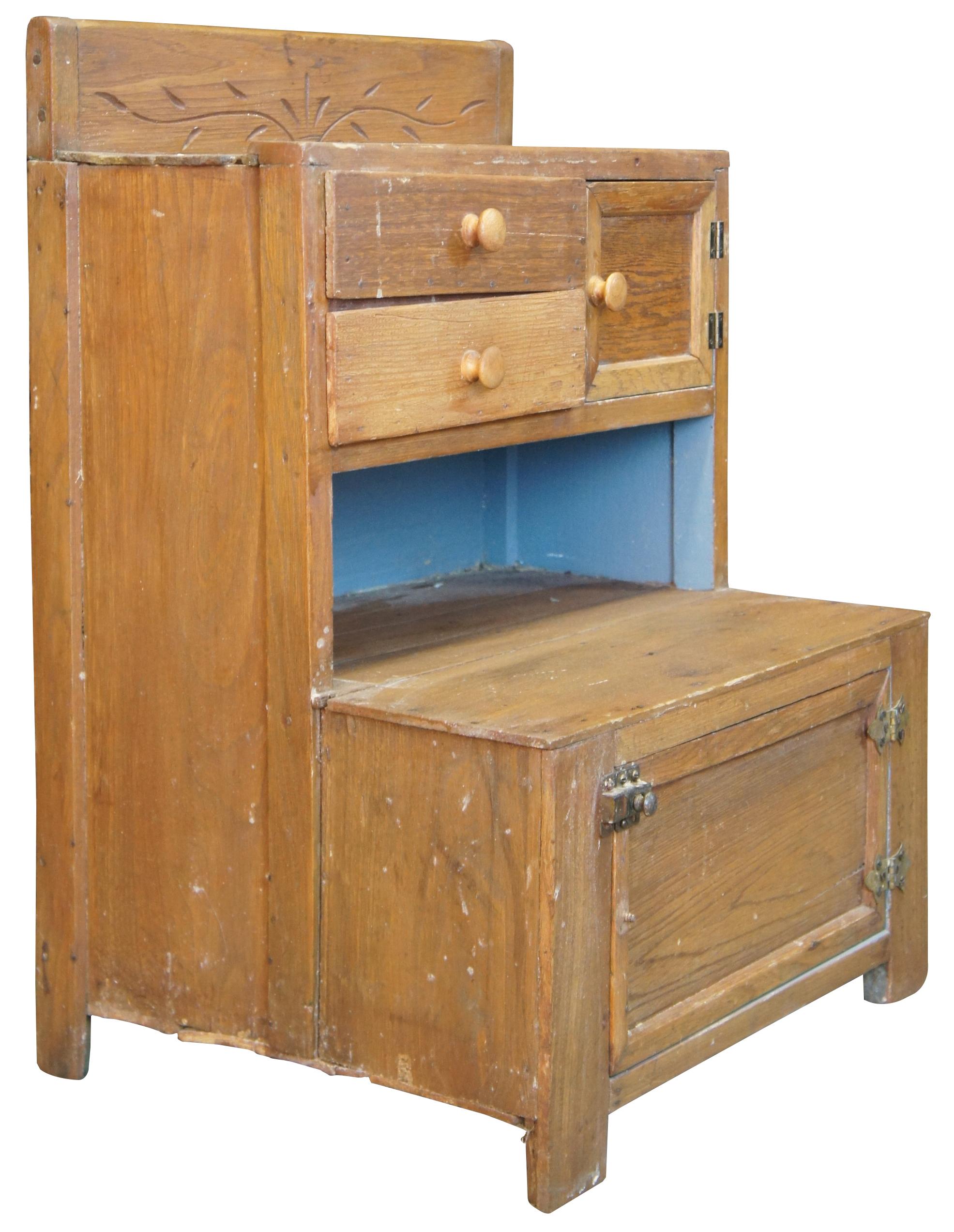 Early 20th century late Victorian American Oak child's stepback cupboard. Features an engraved backsplash, blue interior, brass hardware, two drawers and 2 cabinets for storage. Measure: 25