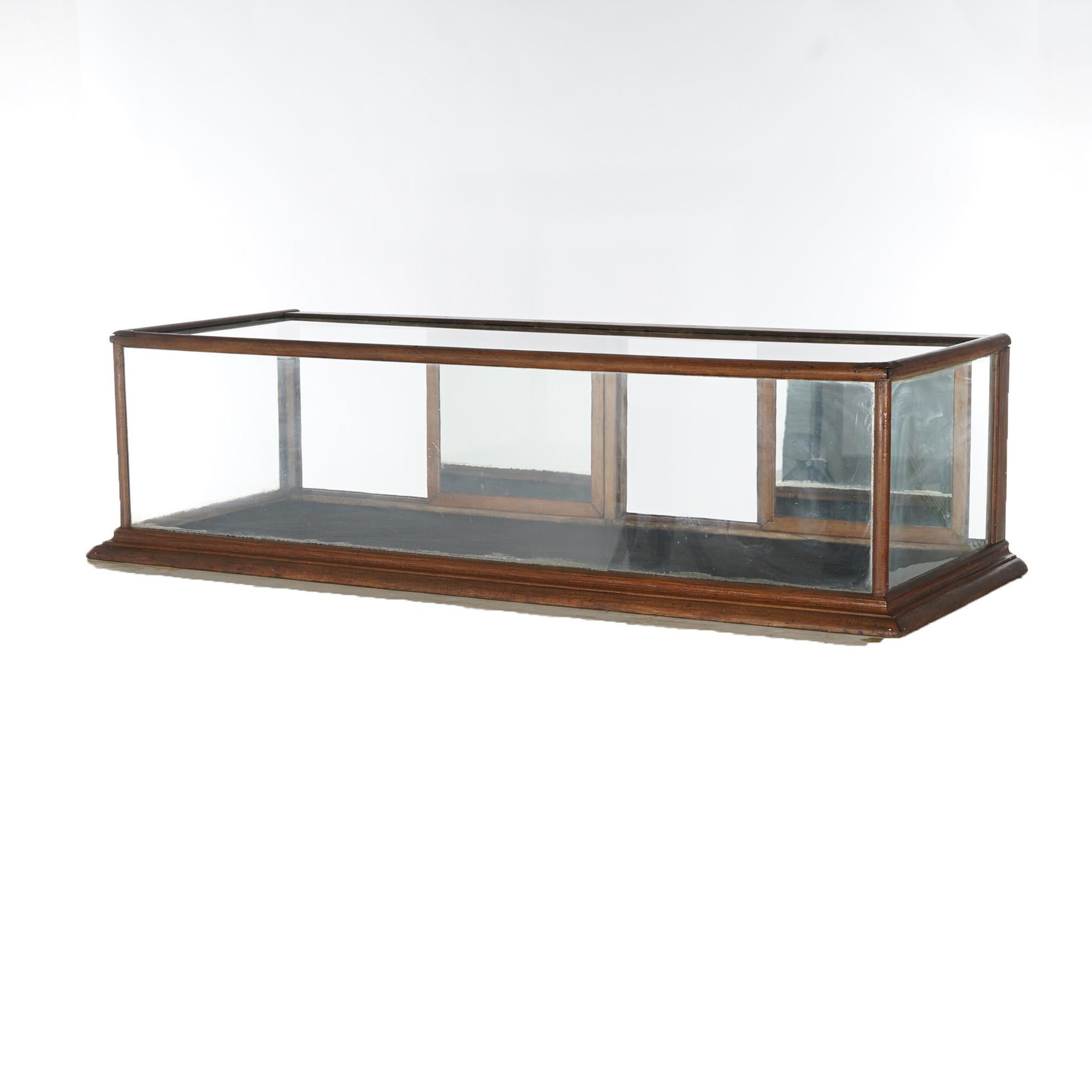 An antique country store table top display case offers walnut frame with glass sides and sliding mirrored doors, c1900

Measures - 17
